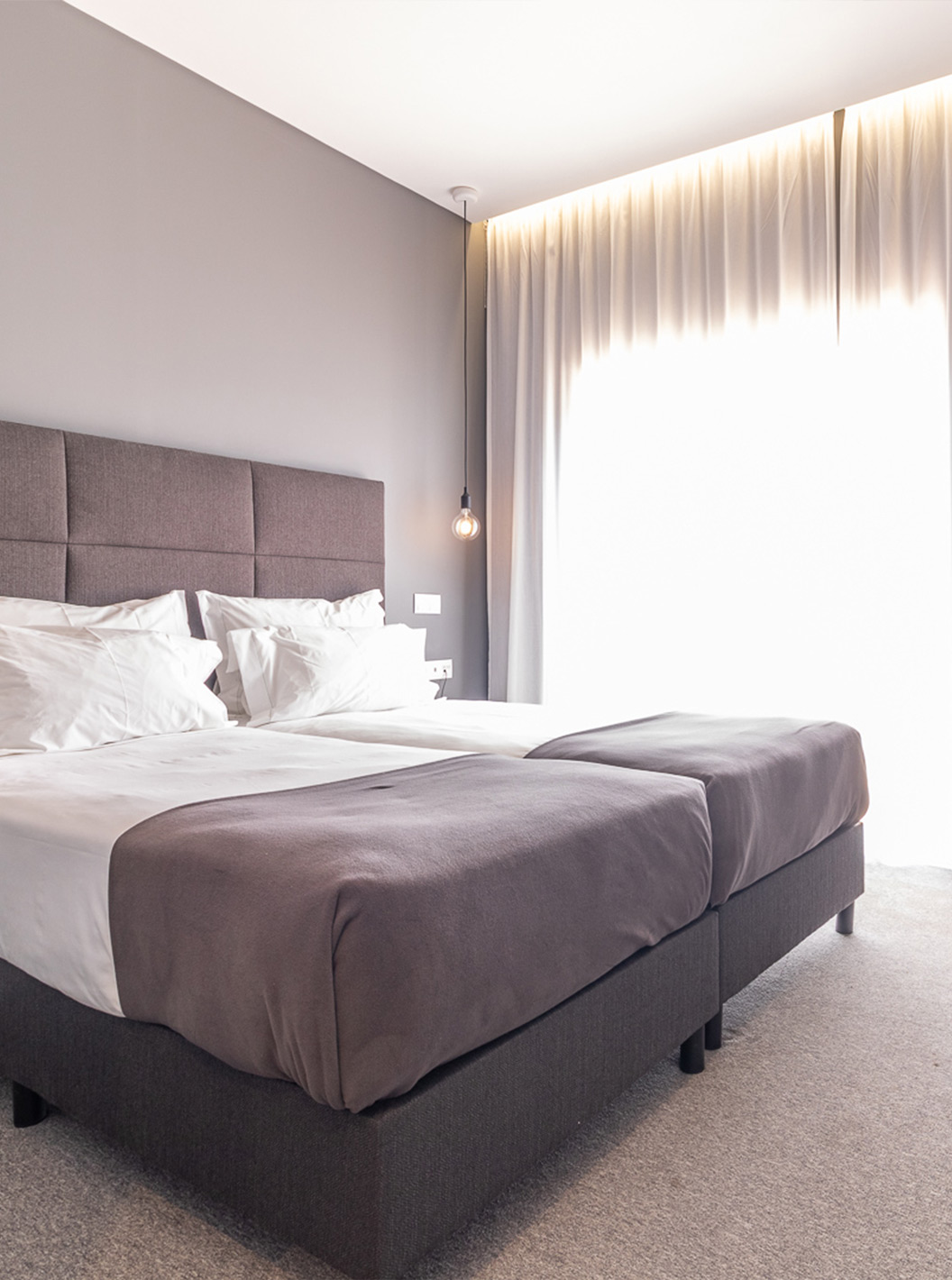 De Klassieke Kamer met Zwembadzicht bij Pestana Gramacho is modern met twee bedden, grijze gordijnen en bloementafel