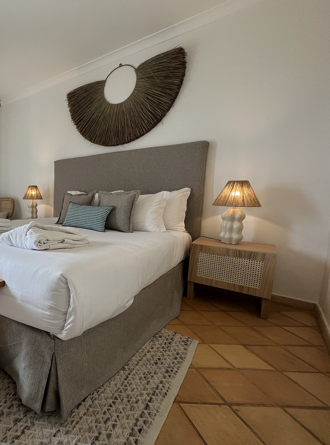 Het Appartement T2 Premium van Pestana Palm Gardens heeft een bed met twee badjassen, kussens en een raam met balkon