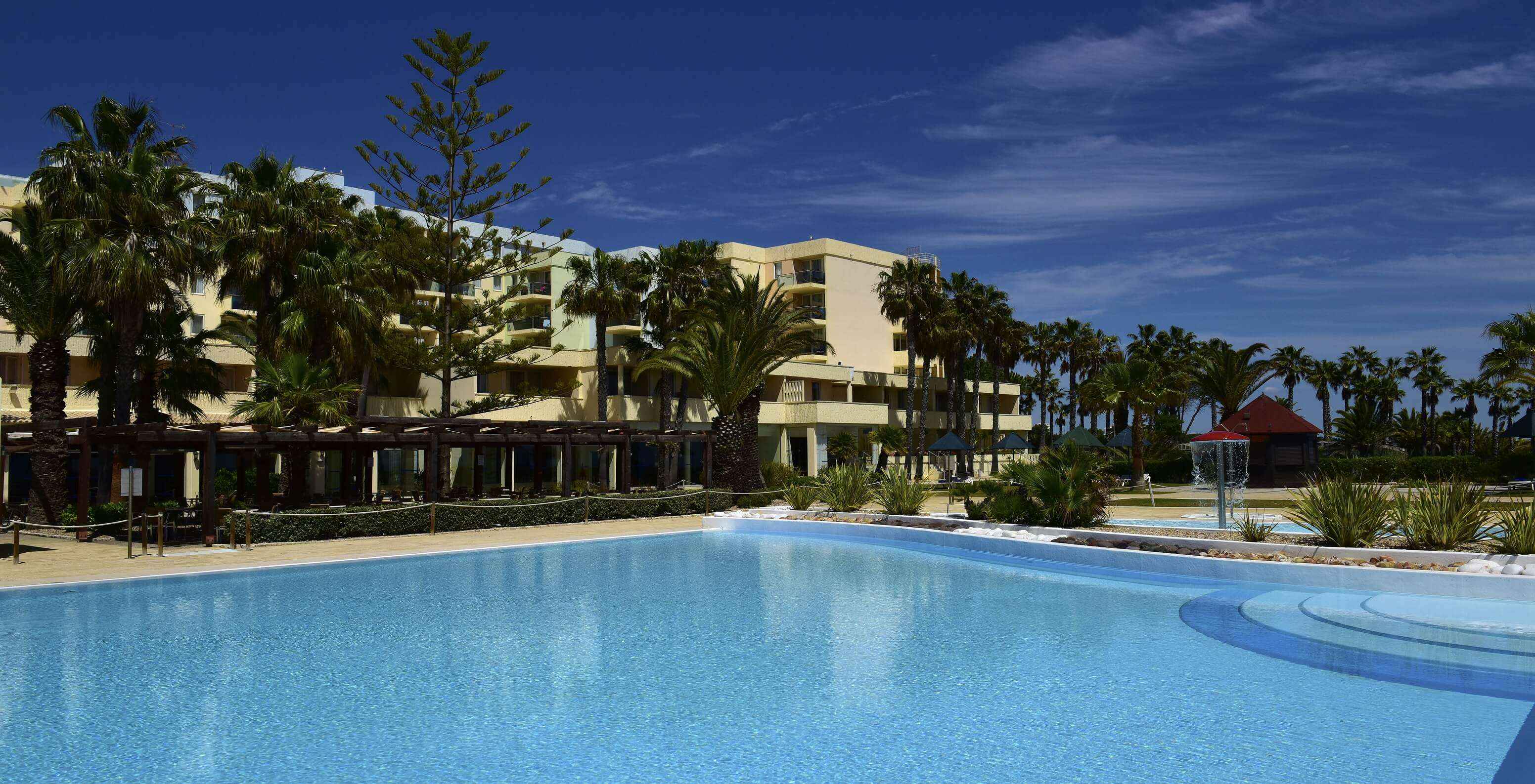 Pestana Viking buitenzwembad op een zonnige dag, met een bar en een klein kinderbad