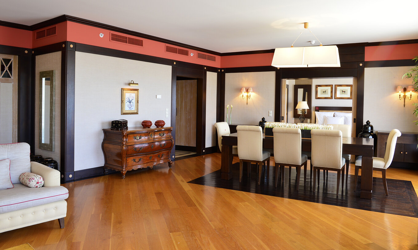 De Presidential Suite van Pestana Vila Sol - Vilamoura heeft een ruime woonkamer met eettafel en houten buffet