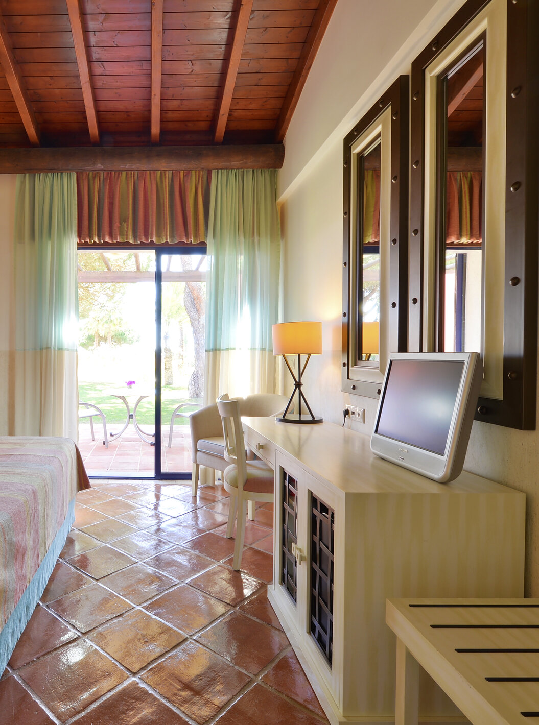 Suite uitzicht tuin Vila Sol van Pestana Vila Sol - Vilamoura heeft een slaapkamer met tweepersoonsbed, spiegel en balkonraam