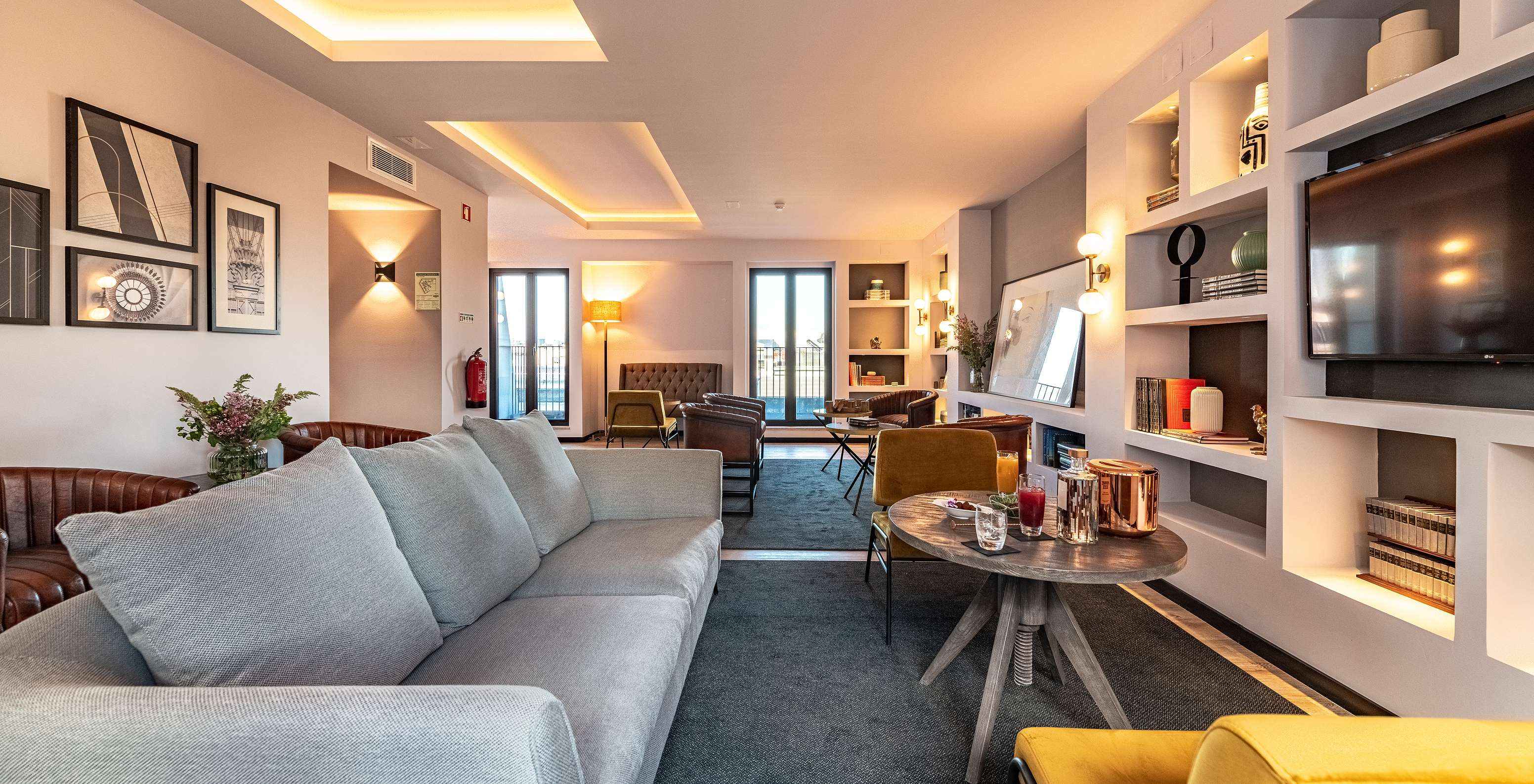 Lounge met banken, stoelen, tafels, schilderijen, televisie, tapijten en decoratieve voorwerpen met uitzicht op de stad