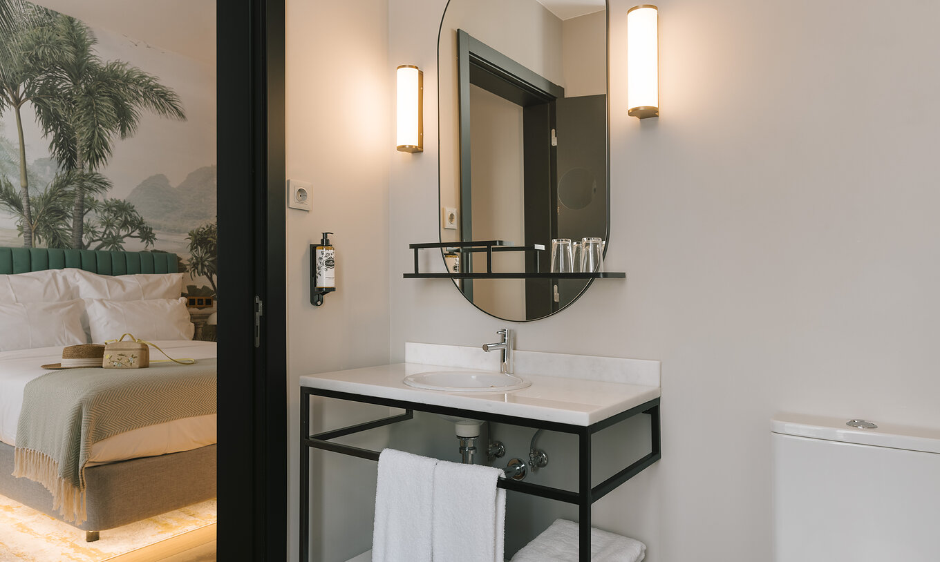 De Superior Kamer van Pestana Rua Augusta Lisboa heeft badkamer met wastafel in wit marmer, met spiegel en handdoeken