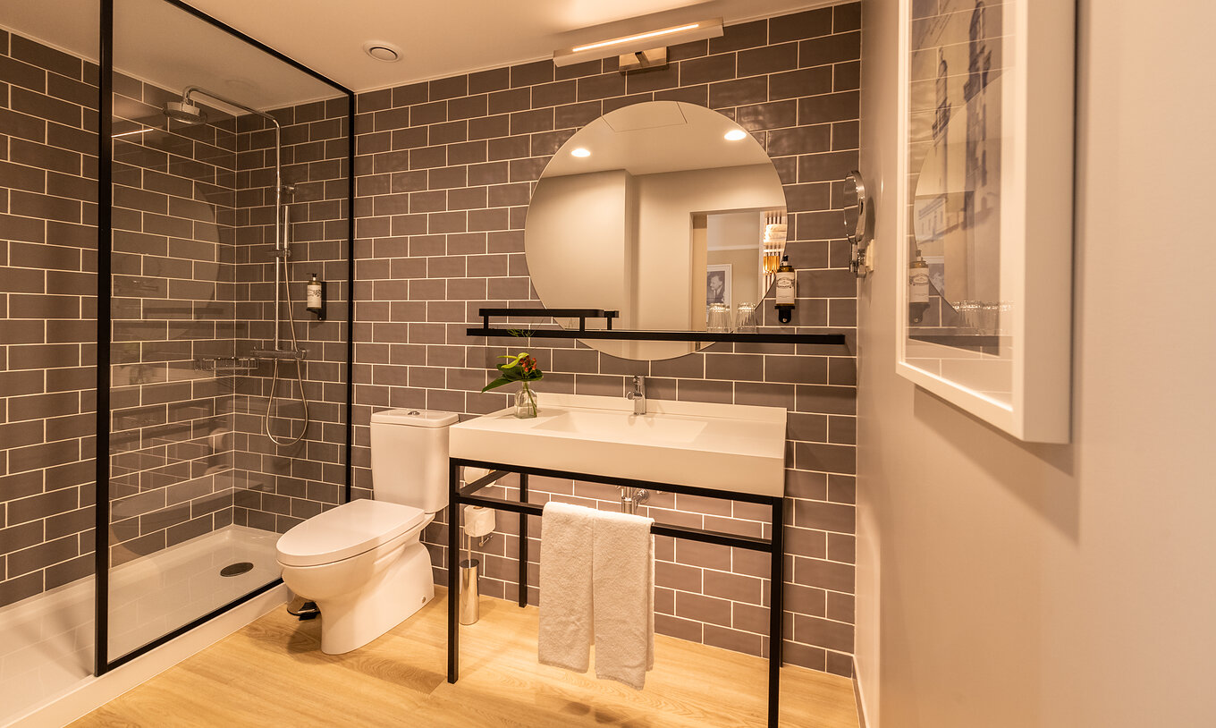 De Superieure Familie van Pestana Fisherman Village heeft een badkamer met douche, toilet en een ronde spiegel