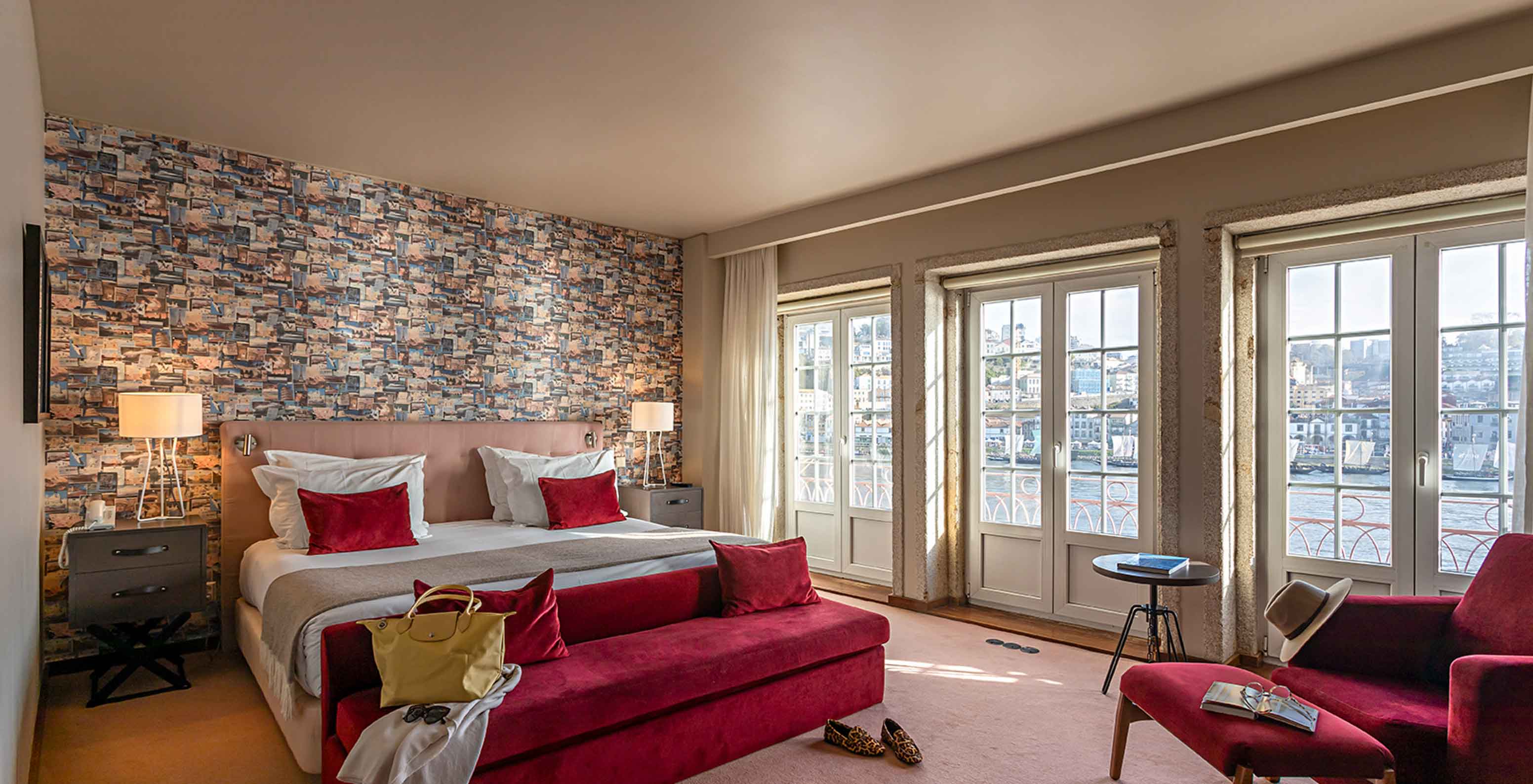 De Suite Grand View van het Pestana Vintage Porto heeft een tweepersoonsbed, een rode bank en ramen met uitzicht op Porto