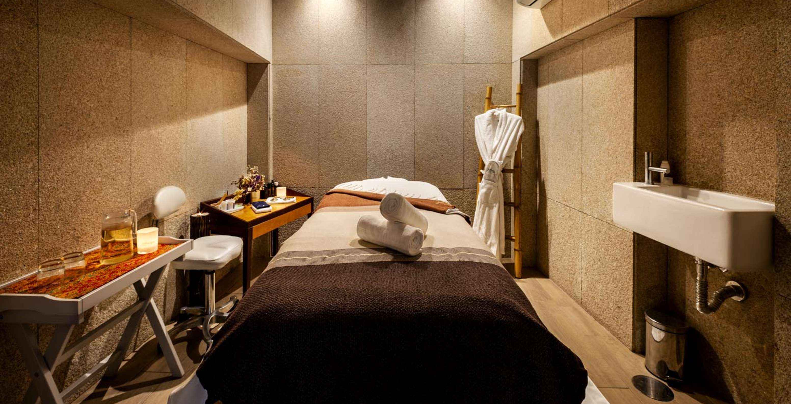 Bed in wellnessruimte, met een tafel met thee bij Pestana Vintage Porto, een Hotel op Praça da Ribeira, Porto