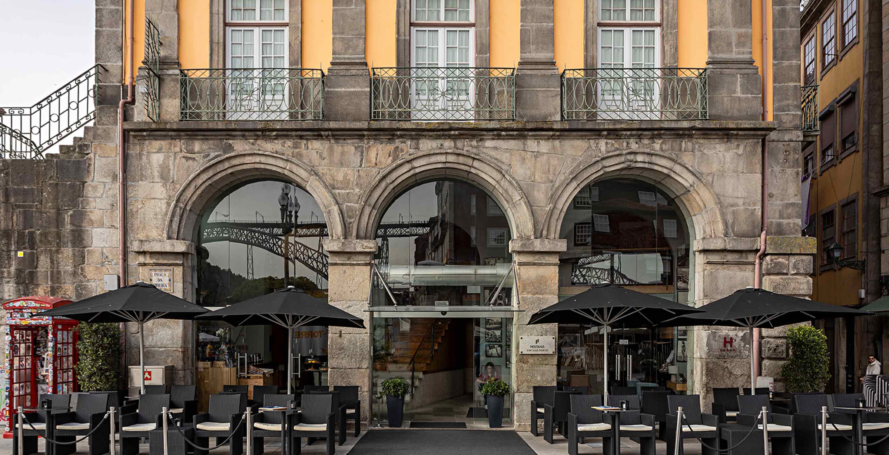 Buitenfaçade van Pestana Vintage Porto met toegang tot een patio met tafels, stoelen en parasols