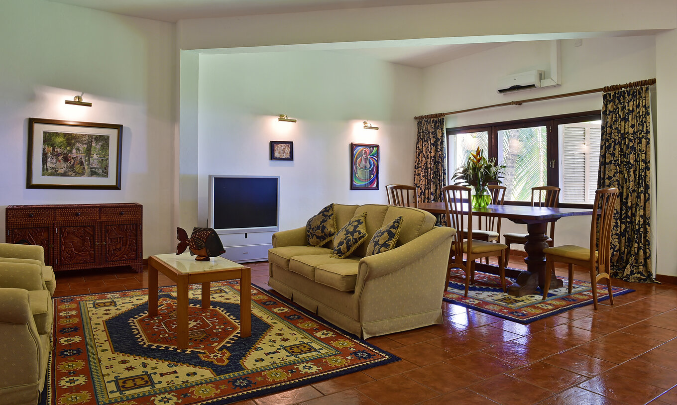 De Presidencial Suite Van Pestana Miramar São Tomé Heeft Een Woonkamer Met Drie Banken Een Eettafel En Televisie