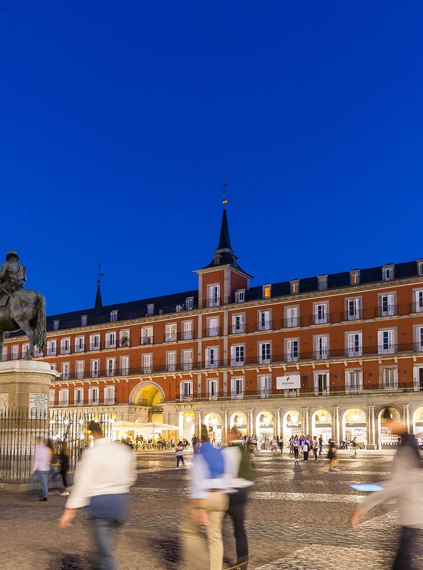Plaza Mayor, Madrid, 's nachts, met veel toeristen die wandelen waar het Pestana Plaza Mayor zich bevindt