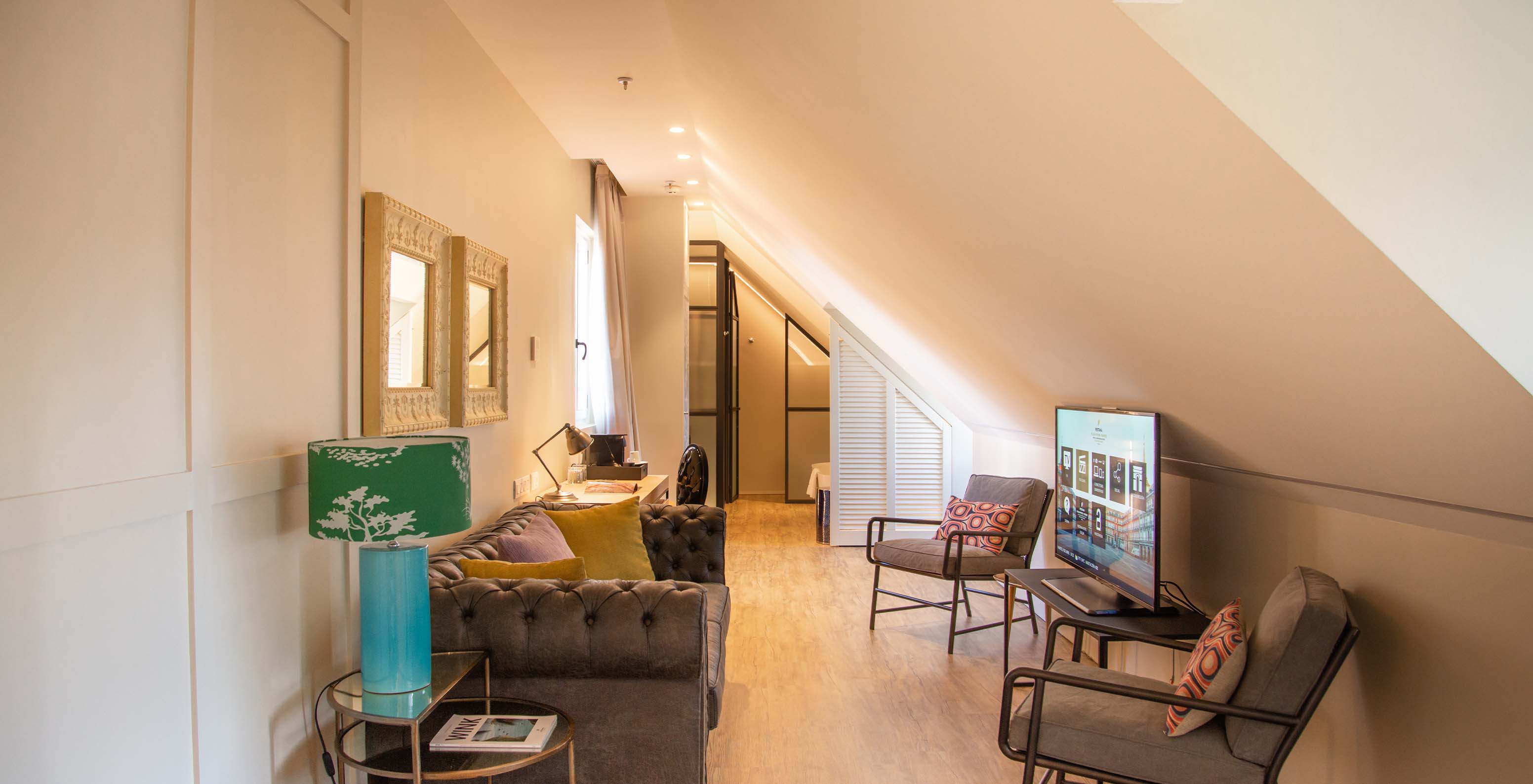 De Suite Plaza Mayor van Pestana Collection Plaza Mayor heeft een woonkamer met bank stoelen tv en schilderijen aan de muur