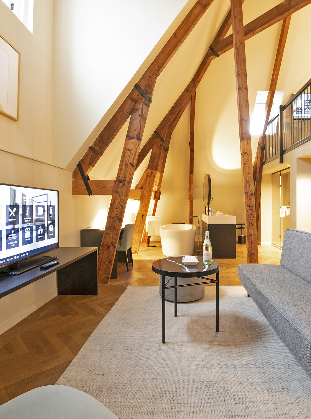 Clock Tower Suite van Pestana Amsterdam Riverside heeft woonkamer met bank, salontafel en televisie