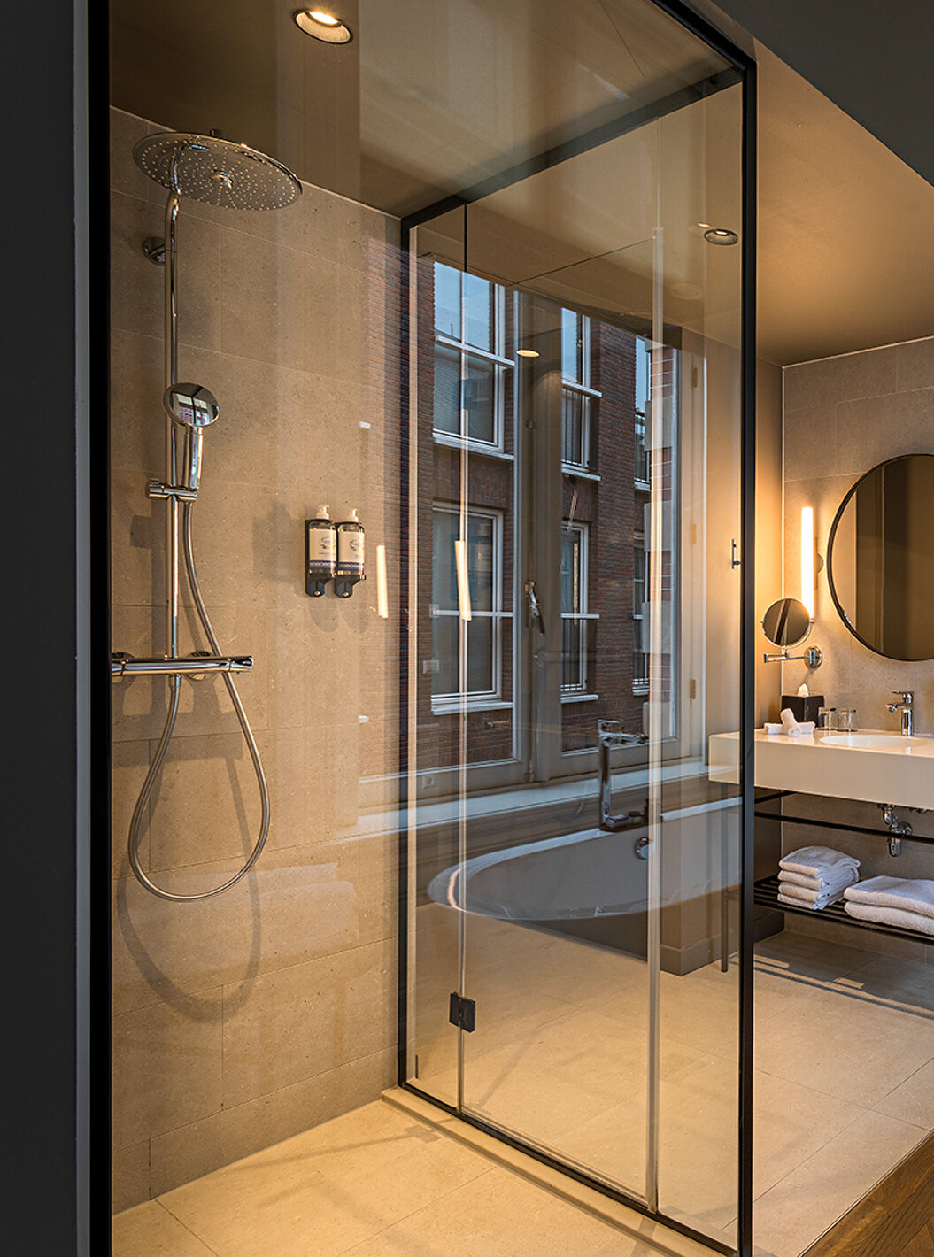 Junior Suite - River View van Pestana Amsterdam Riverside heeft badkamer met spiegel, wastafel en douche