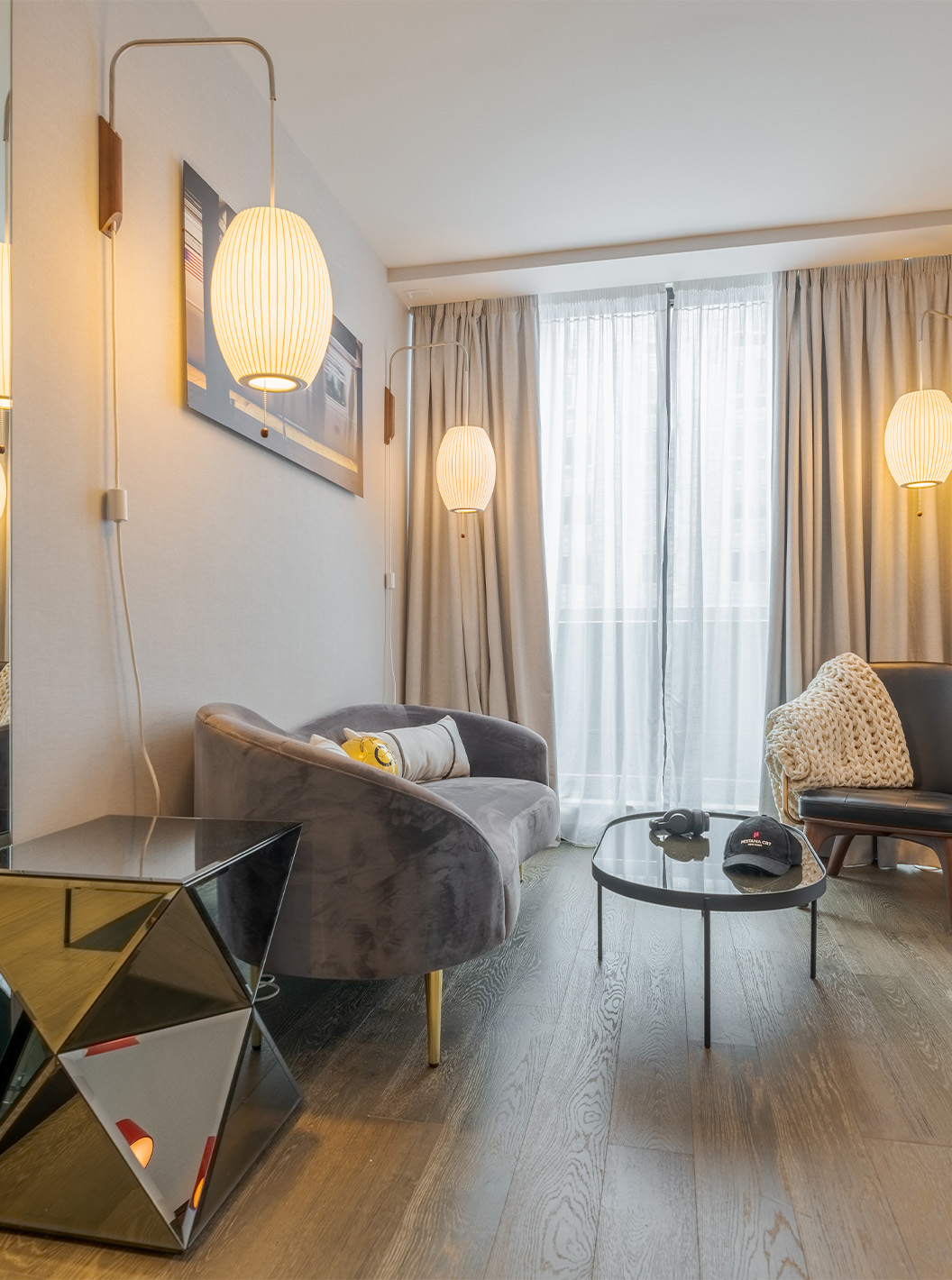 Een Junior Suite met Balkon en Uitzicht van Pestana CR7 Times Square heeft een woonkamer met een bank, grote ramen en stoel