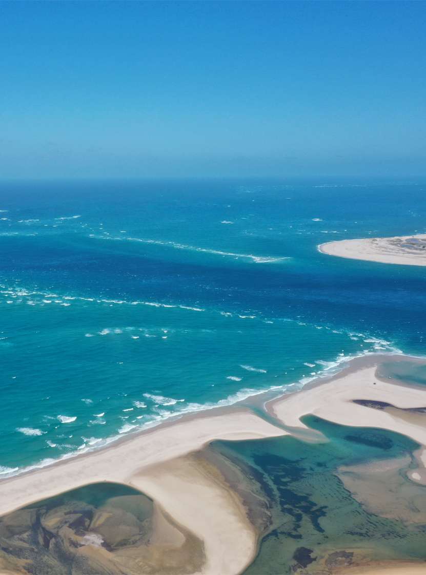 Vista aérea deslumbrante da baía de Bazaruto, com as suas águas cristalinas, dunas de areia branca e recifes de coral