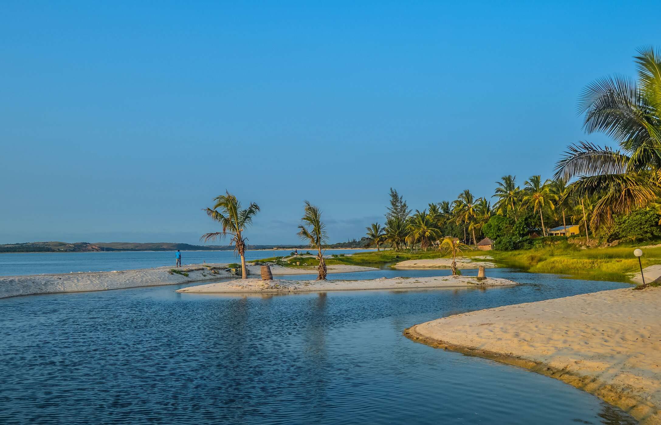 Praia Bilene em Maputo no pôr-do-sol, com uma pequena lagoa entre a areia