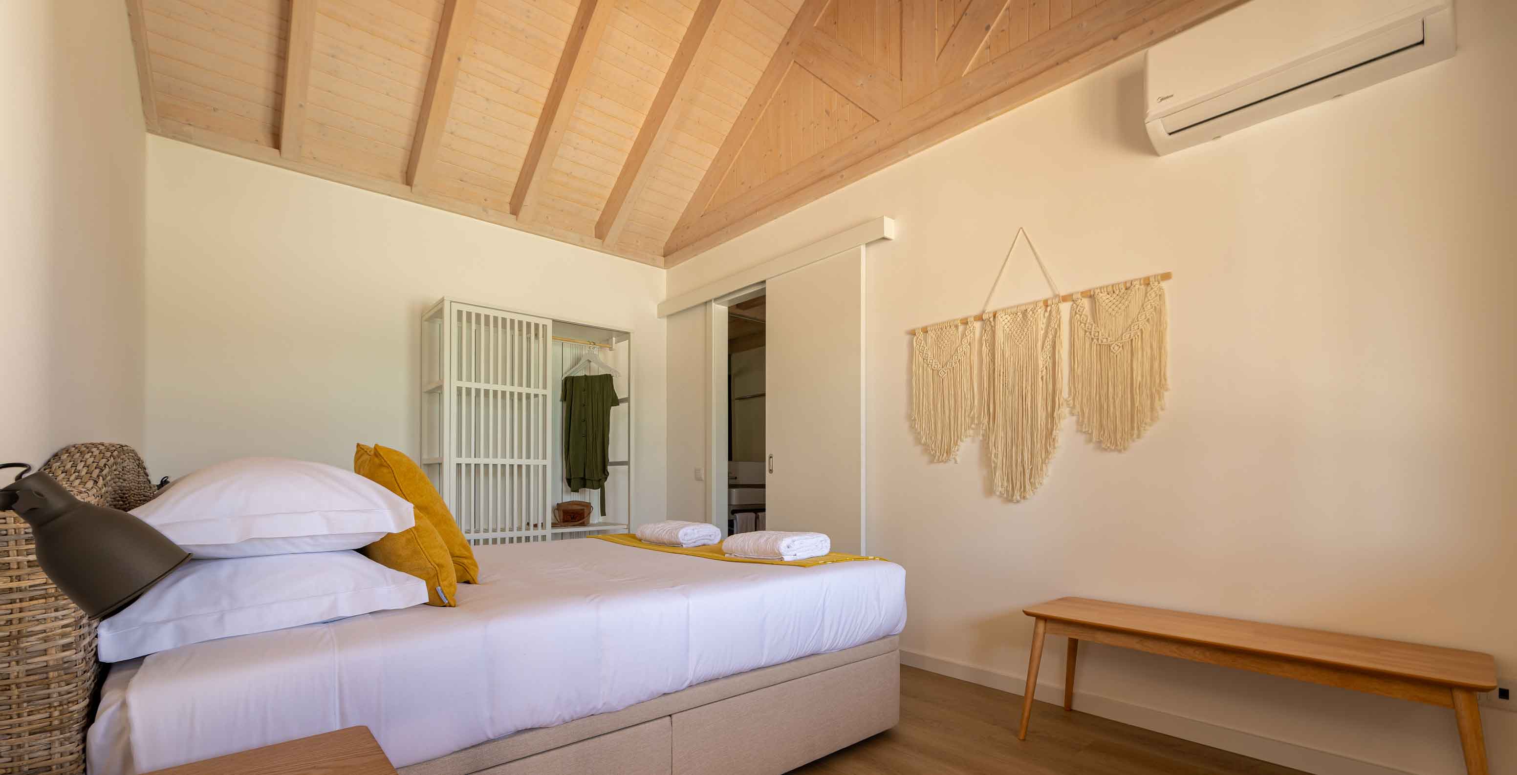 A Premium Green Villa do Pestana Comporta Village Residences tem um quarto com uma cama, ar condicionado e decoração