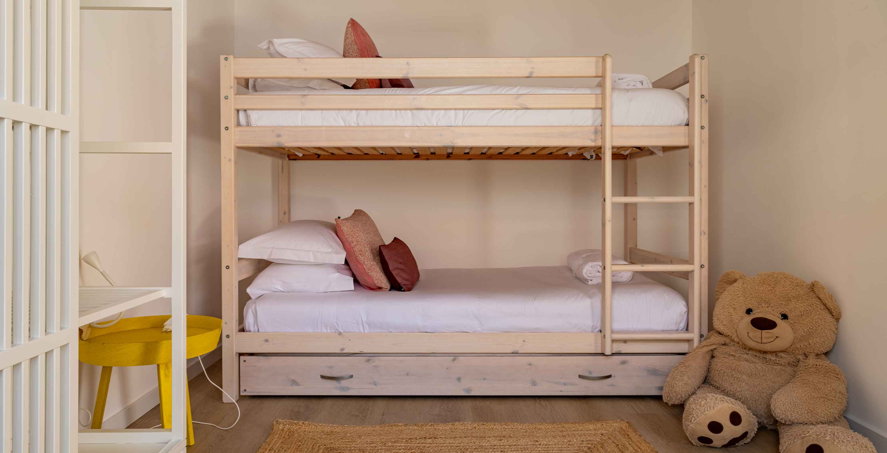 A Premium Green Villa do Pestana Comporta Village Residences tem um beliche de madeira de duas camas e um urso de peluche