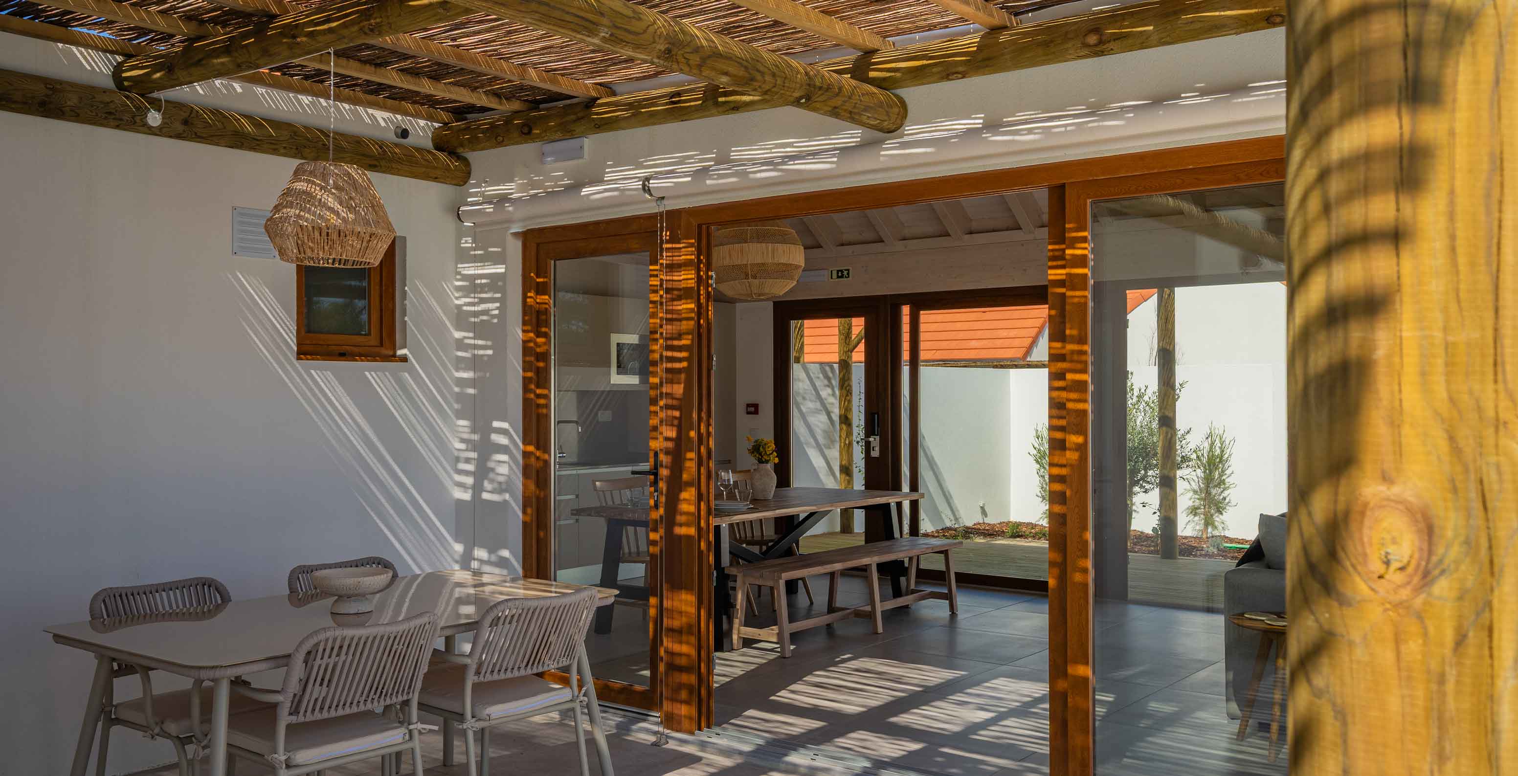 A Premium Green Villa do Pestana Comporta Village Residences tem um pátio coberto com uma mesa que dá acesso ao interior
