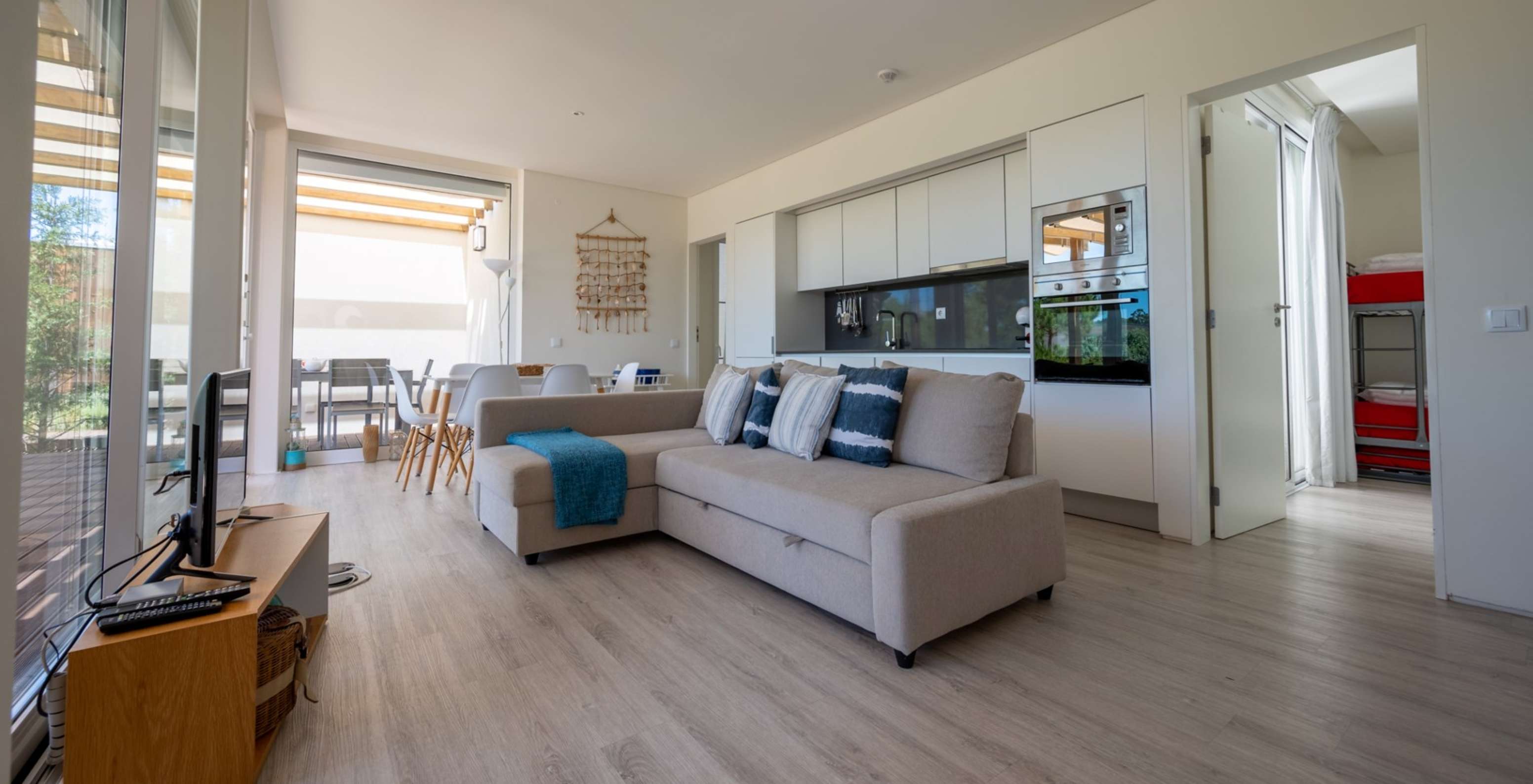 A Green Villa com Piscina Privada do Pestana Tróia Eco Resort tem uma sala junta com a cozinha, com sofá, mesa e televisão