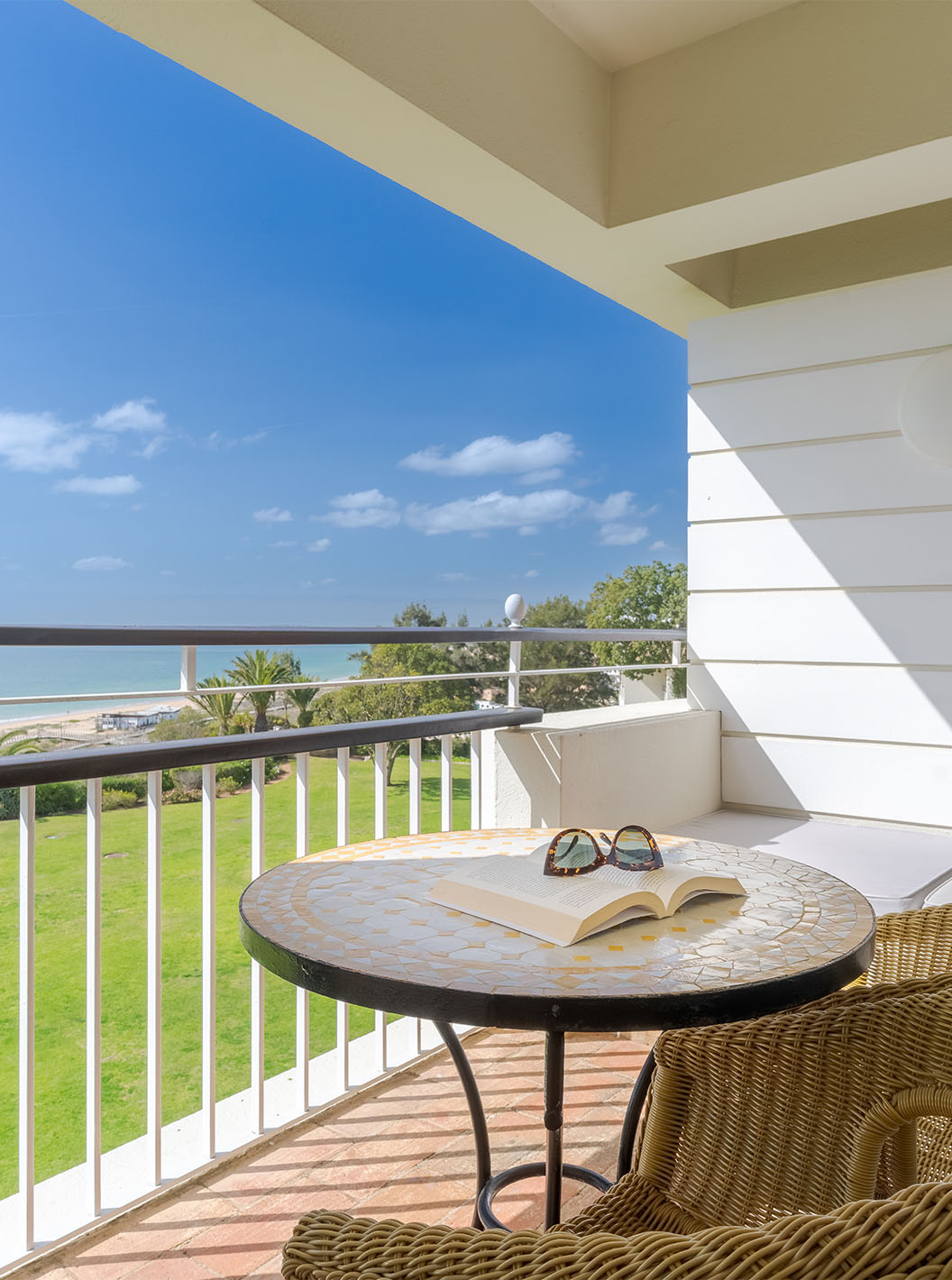 O Deluxe Vista Mar do Pestana Alvor Praia tem varanda com cadeiras, mesa e sofá com vista para o mar, praia e jardim do hotel