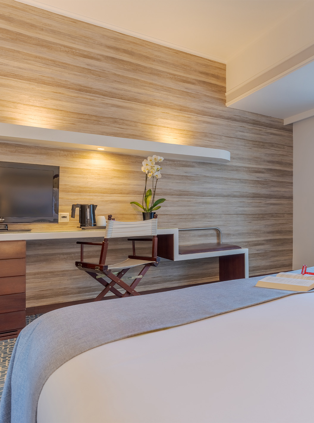 O Deluxe do Pestana Alvor Praia tem uma cama de casal, televisão na secretária, cadeirão azul e janela para a varanda