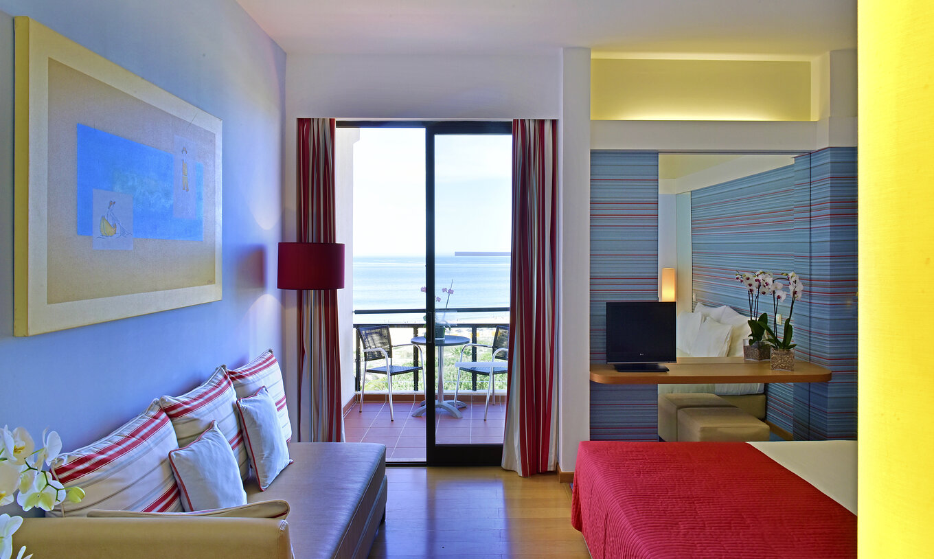 O Deluxe Vista Mar do Pestana Dom João II conta com um sofá e uma varanda, com mesas e cadeiras, com vista para o mar
