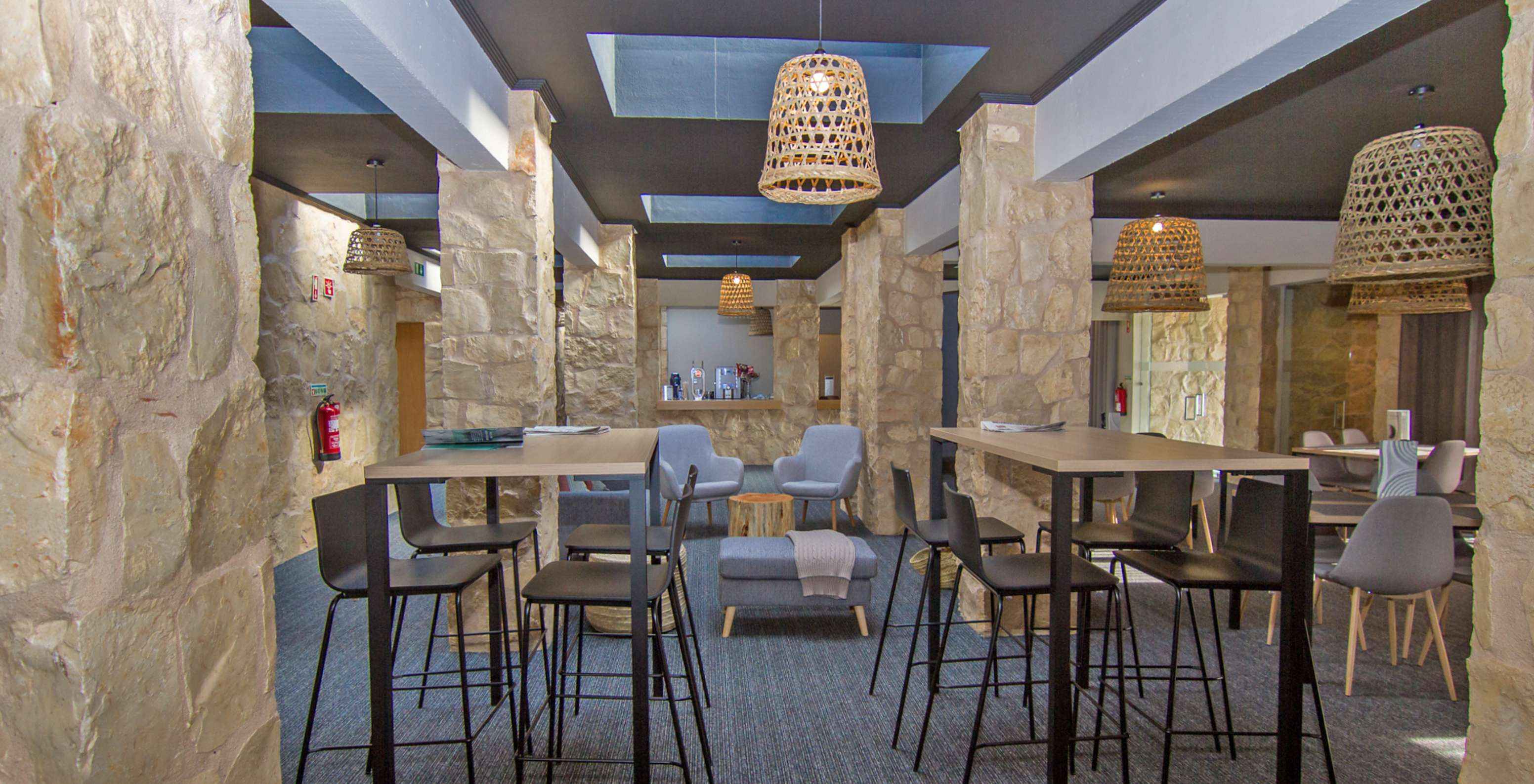 Restaurante de hotel com piscina, localizado num Campo de Golfe, com duas mesas altas e mesas com cadeiras confortáveis