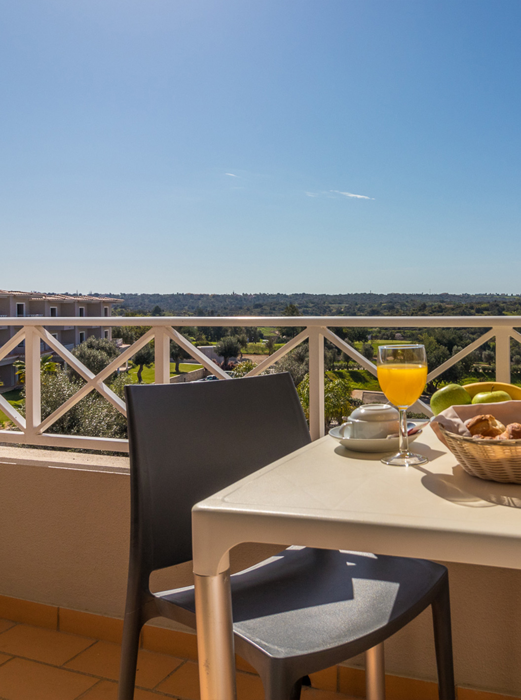 O Studio do Pestana Gramacho Residences tem uma mesa ao ar livre em cenário ensolarado e acolhedor com vegetação.