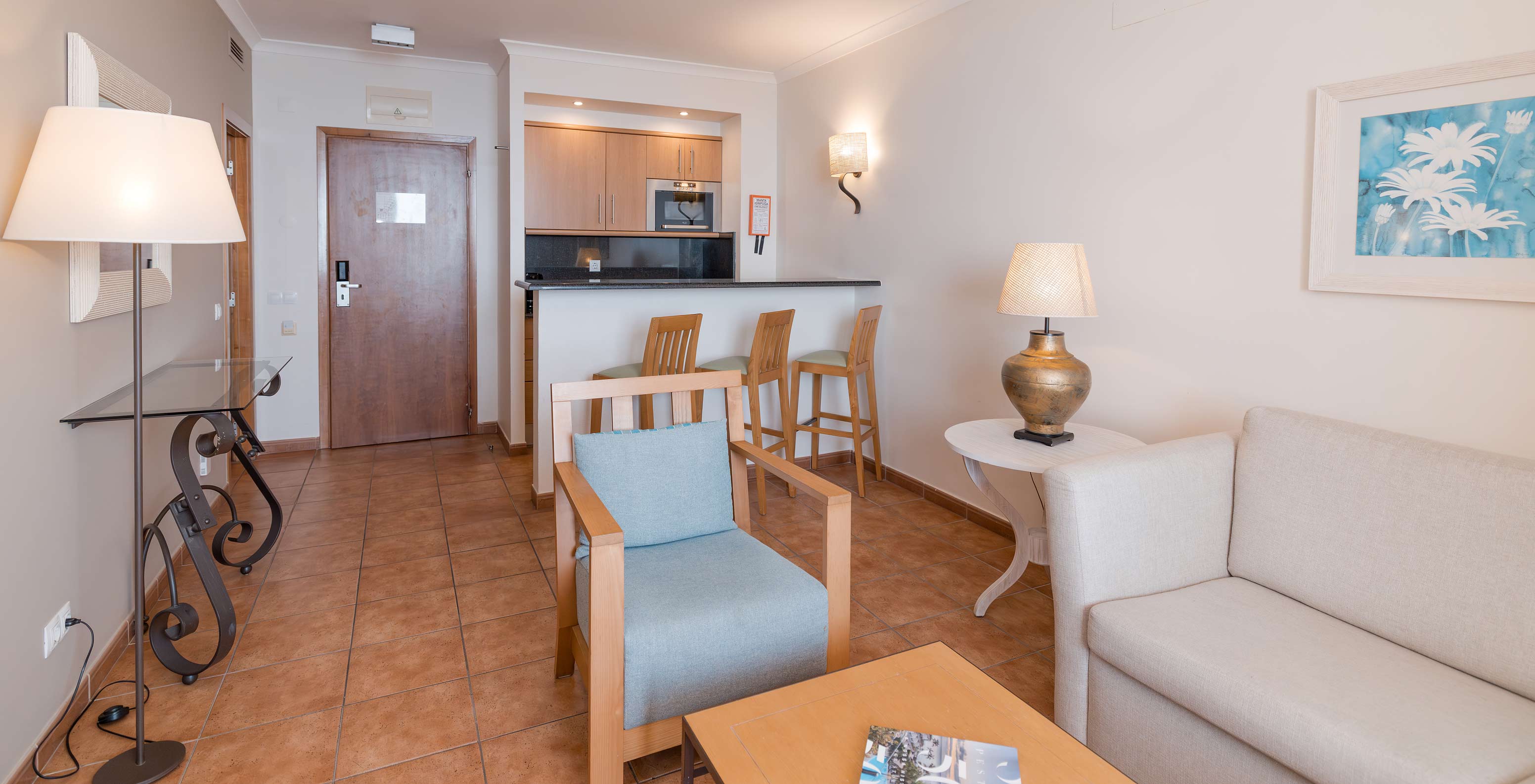 A Suite Superior Vista Mar do Pestana Viking tem uma sala com sofá, poltronas e uma pequena cozinha equipada com microondas