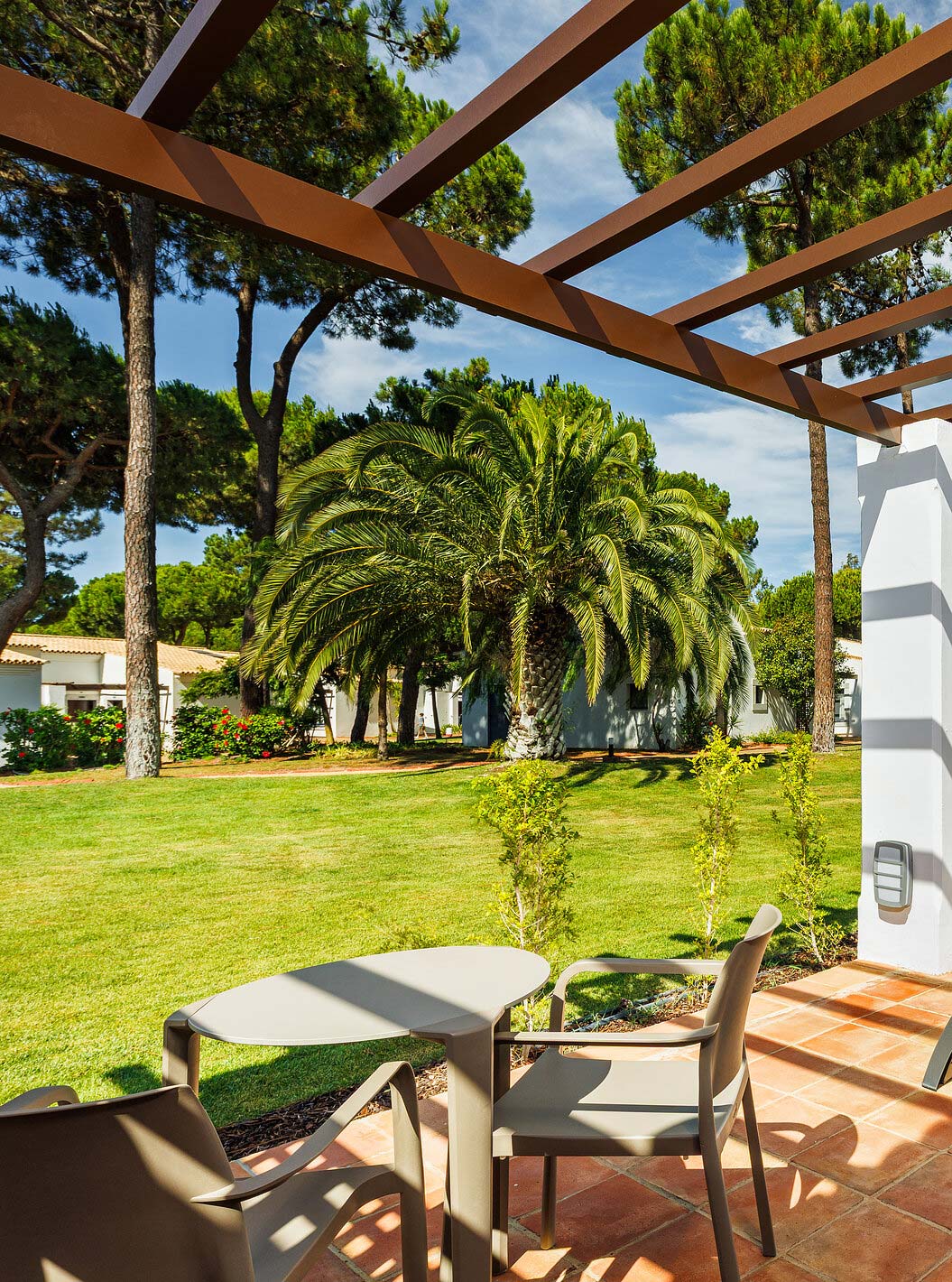 O Familiar Vista Jardim do Pestana Vila Sol - Vilamoura tem uma varanda com espreguiçadeira, mesa e vista para o jardim