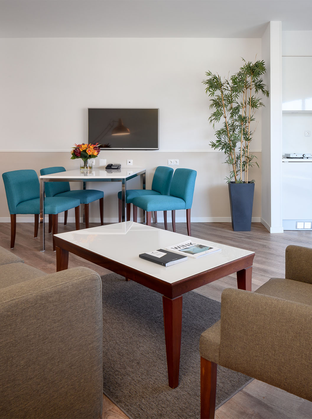 A Suite Deluxe do Pestana Cascais conta com uma sala de estar, com sofá, mesa de centro, mesa de jantar e televisão 