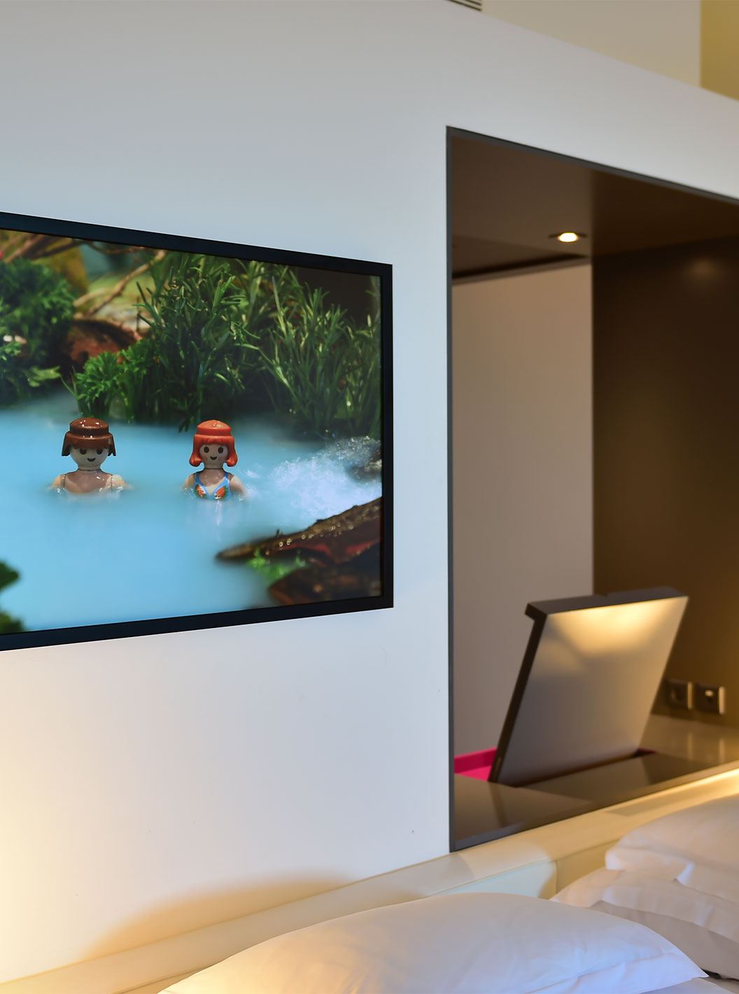 A Junior Suite Art District do Pestana Cidadela Cascais tem um quadro colorido com elementos Playmobil na parede