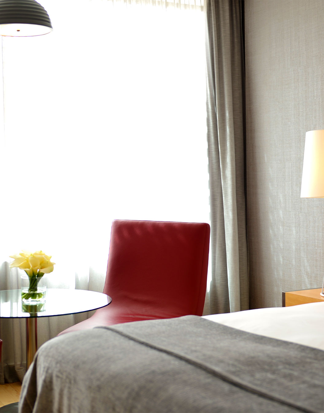 O Quarto Superior com Varanda do Pestana Cidadela Cascais tem uma cama de casal e uma peqiena mesa com uma cadeira vermelha