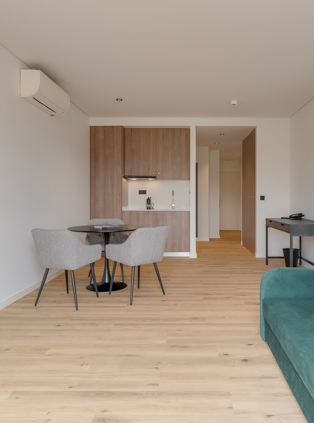 O Familiar com Varanda - Clubhouse do Pestana Sintra Golf tem um sofá, televisão, ar condicionado, uma mesa e kitchenette