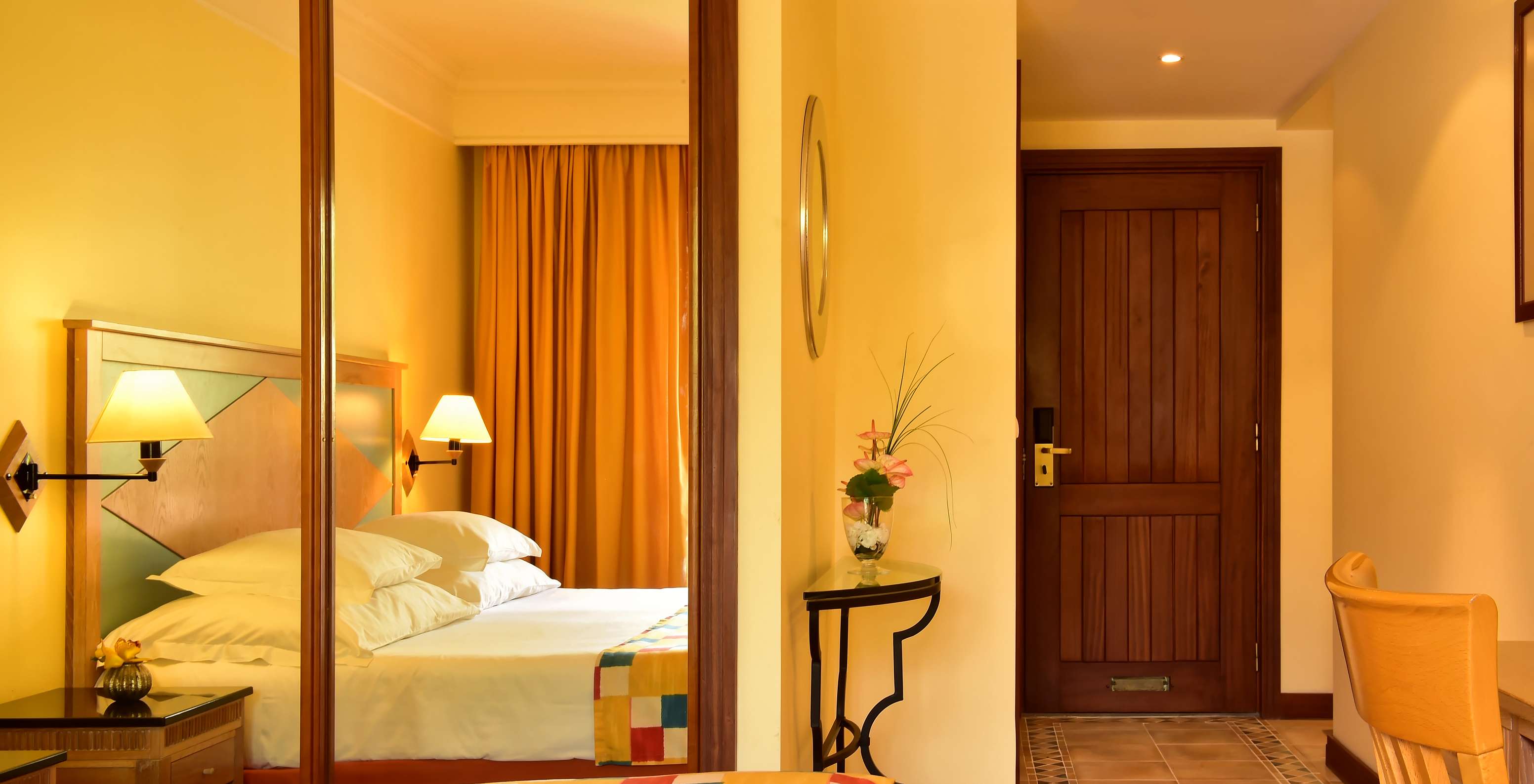 O Superior do Pestana Miramar tem uma cama de casal com uma colcha aos quadrados e um armário com espelho