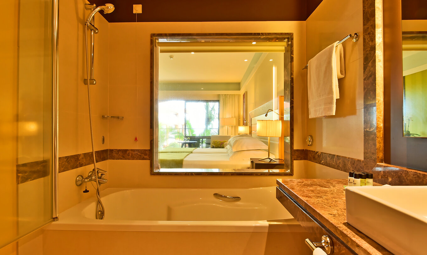 O Superior do Pestana Promenade tem uma casa de banho com banheira, amenities e um vidro com vista para o quarto