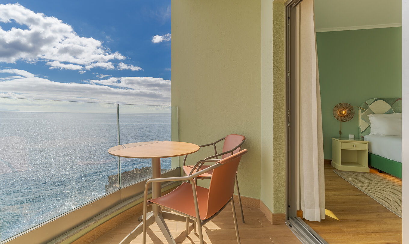 O Clássico Vista Mar do Pestana Vila Lido Madeira tem uma varanda com uma mesa, cadeiras e vista para o mar