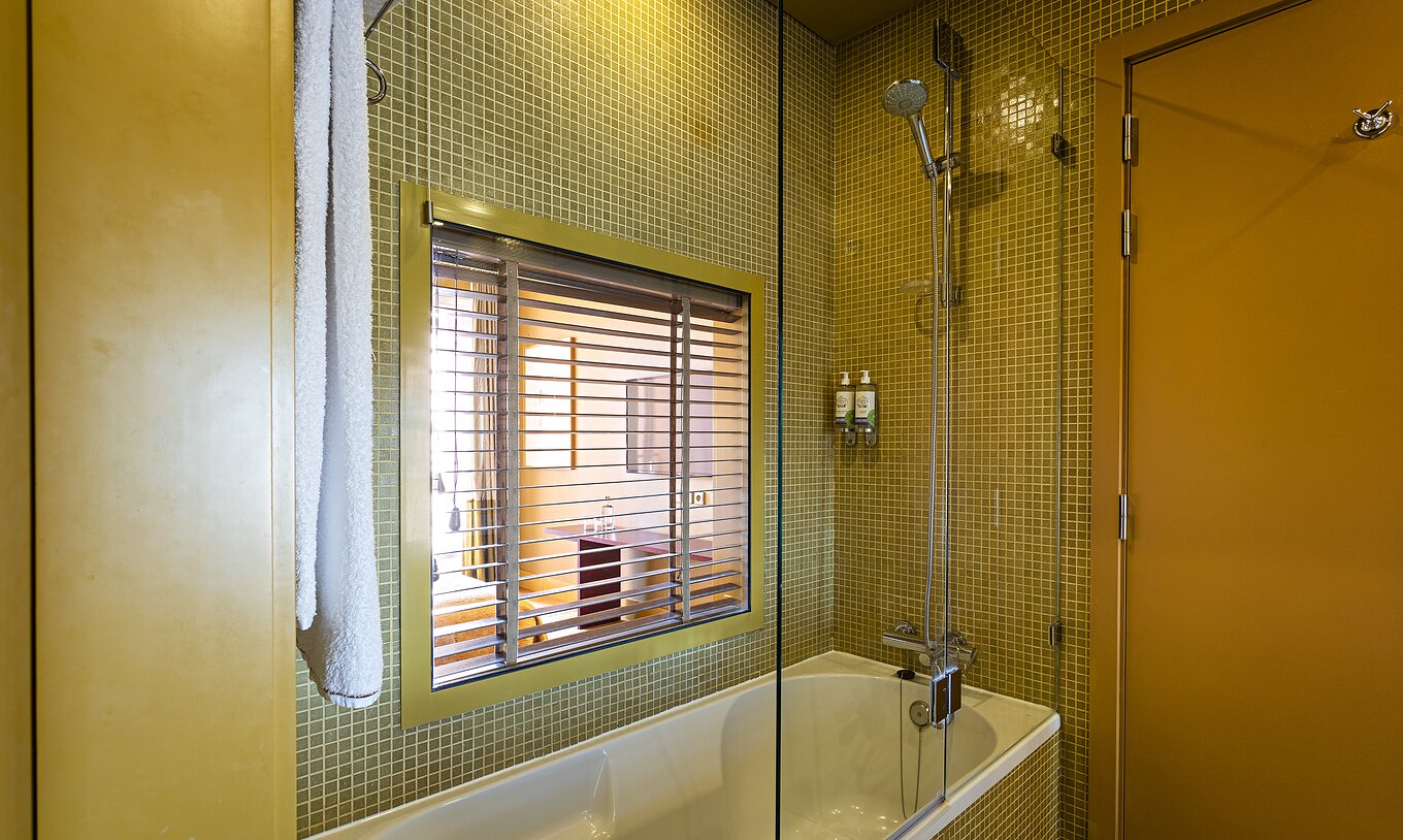 A Suite Balcony do Pestana Palácio do Freixo tem uma casa de banho com banheira e janela para o quarto