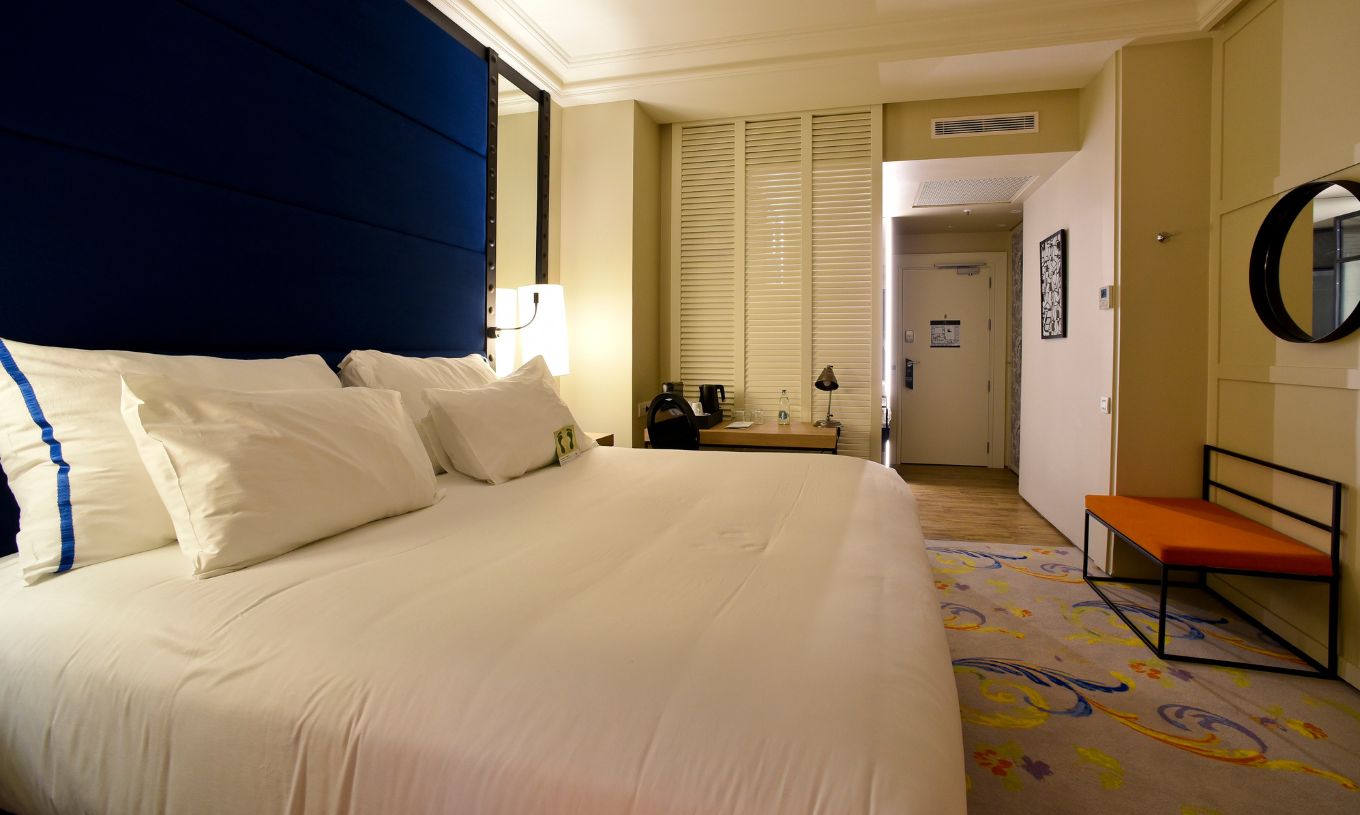 O Quarto Superior Plus do Pestana Plaza Mayor Madrid tem uma cama de casal com um candeeiro e tapete