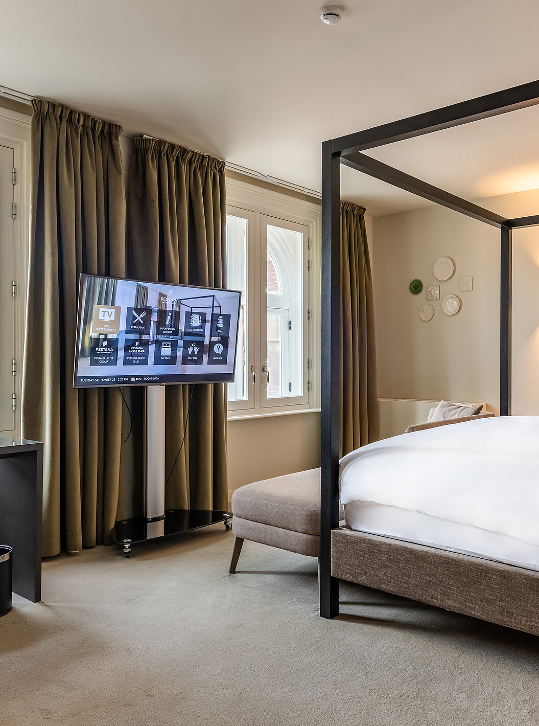 O quarto Premium Deluxe do Pestana Amsterdam Riverside tem uma televisão à frente da cama e uma secretária com cadeira