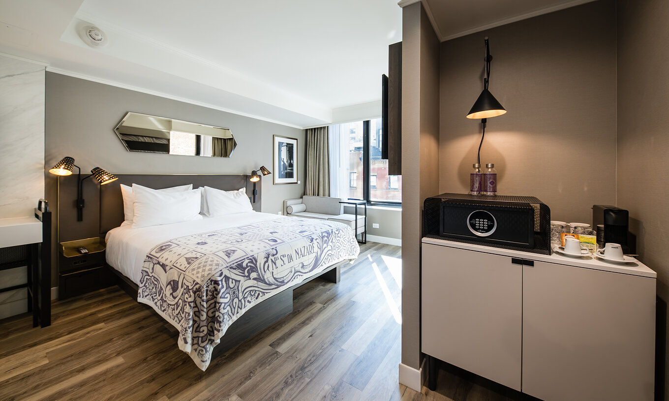 O quarto Superior do Pestana Park Avenue conta com uma cama de casal, cofre, máquina de café e água engarrafada