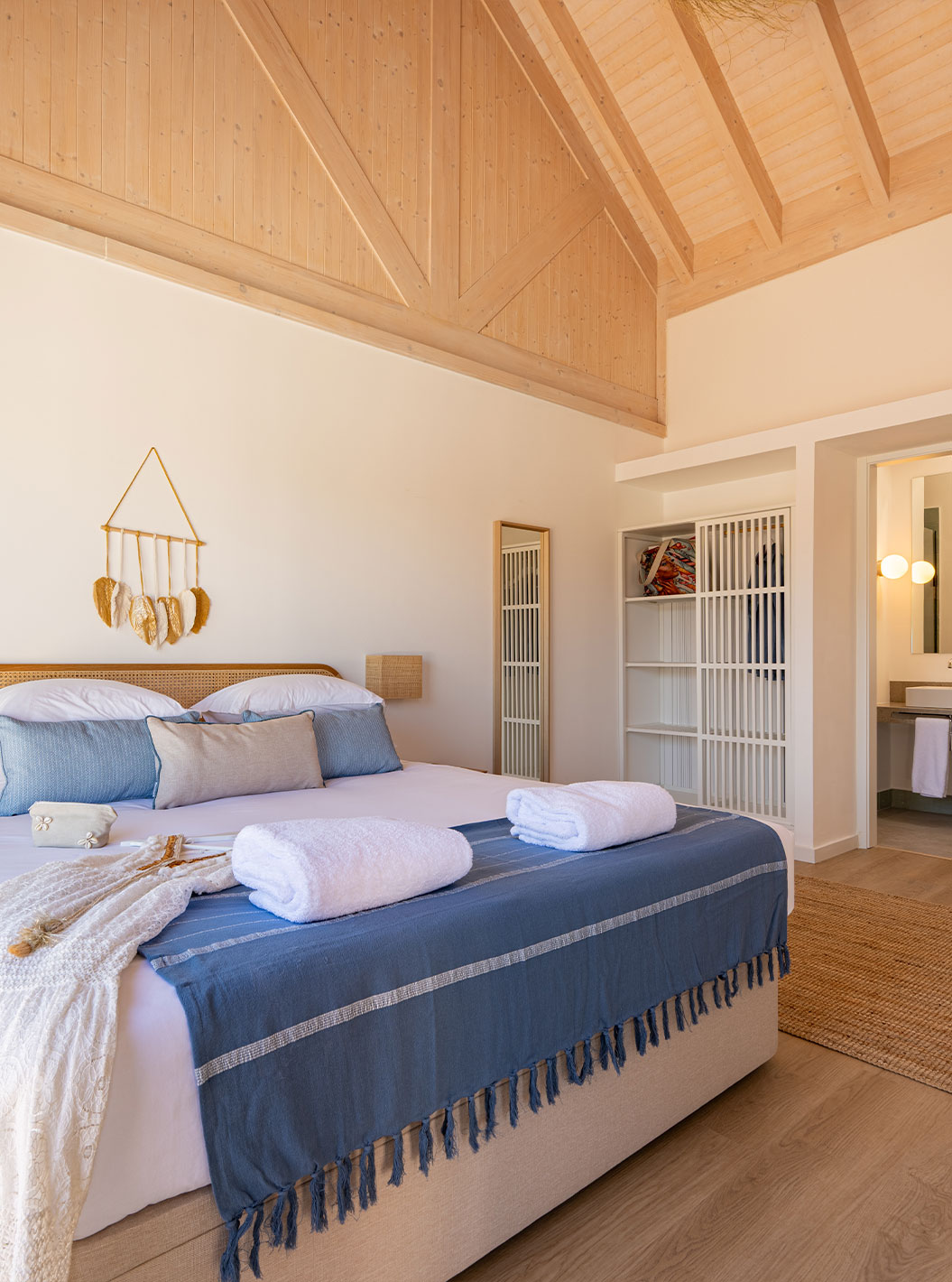 A Premium Green Villa do Pestana Comporta Village Residences tem um quarto com uma cama de casal e várias almofadas azuis