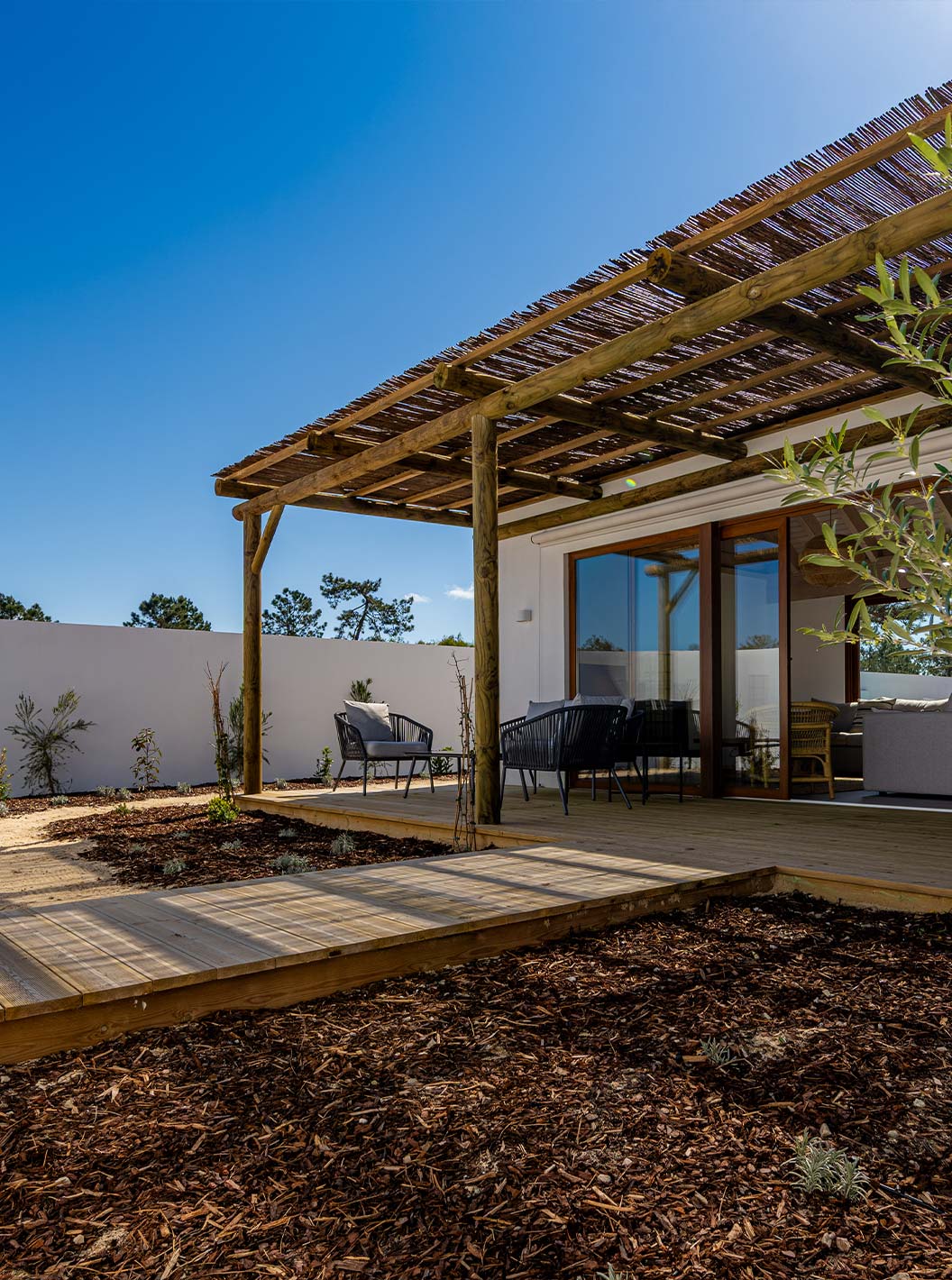 A Premium Green Villa do Pestana Comporta Village Residences tem um pátio em deck de madeira e uma pérgola que faz sombra