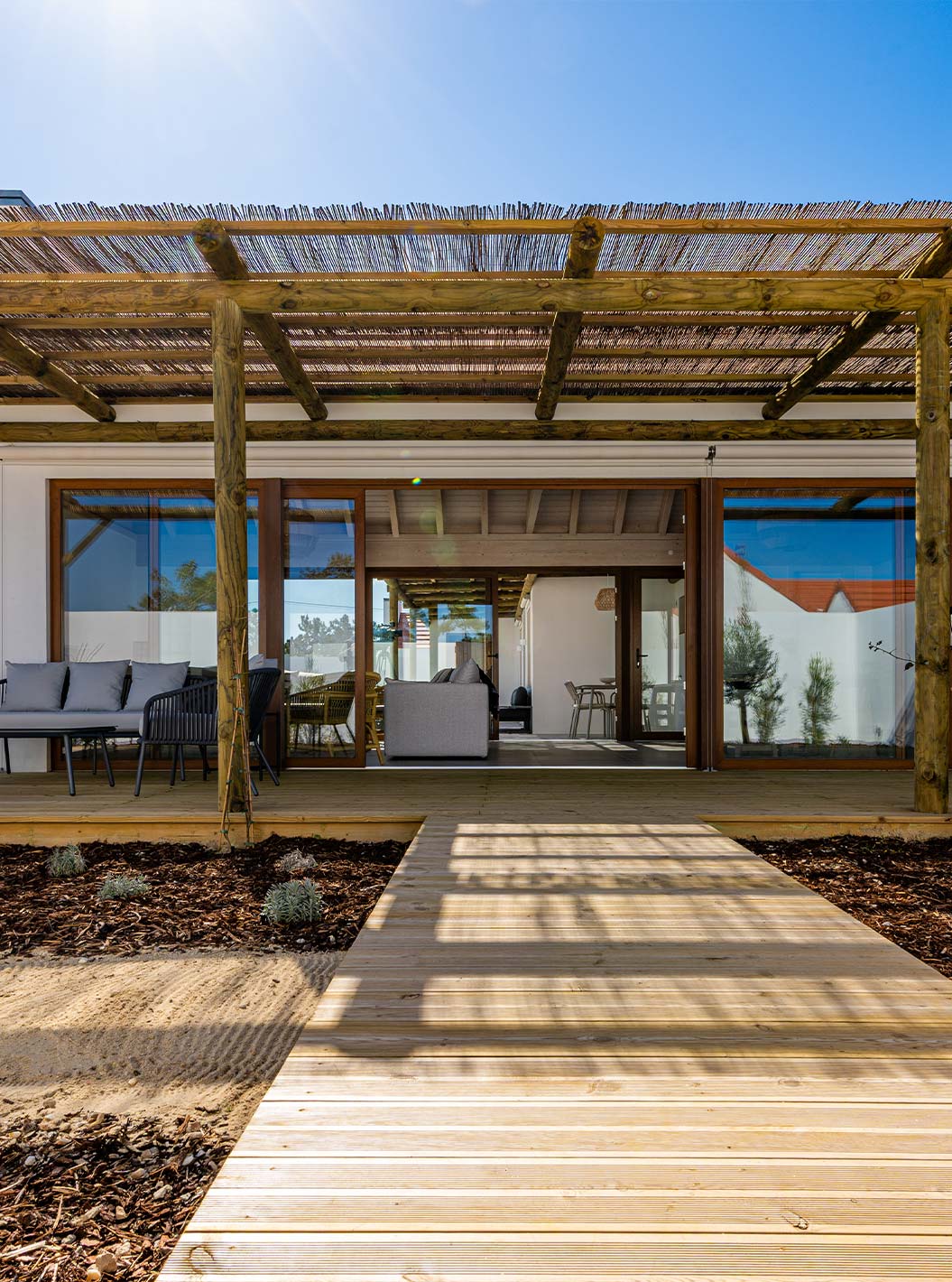 A Premium Villa do Pestana Comporta Village Residences tem uma entrada com deck de madeira, uma pérgola e um jardim