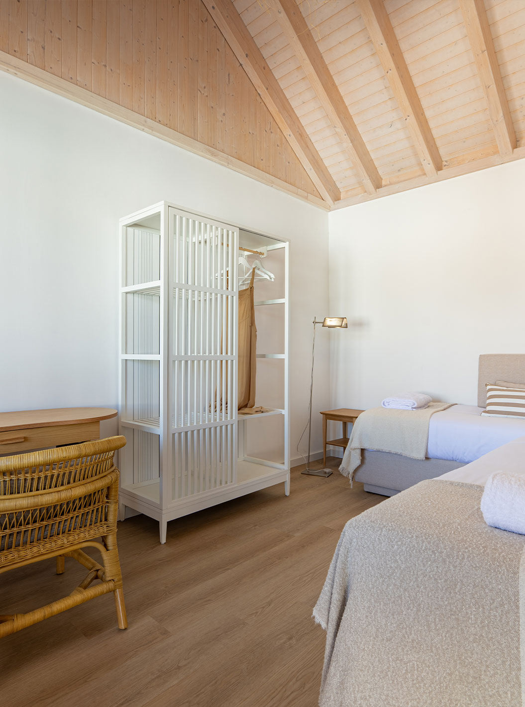 A Standard Villa do Pestana Comporta Village Residences tem um quarto com cama, uma mesa e uma cadeira de vime