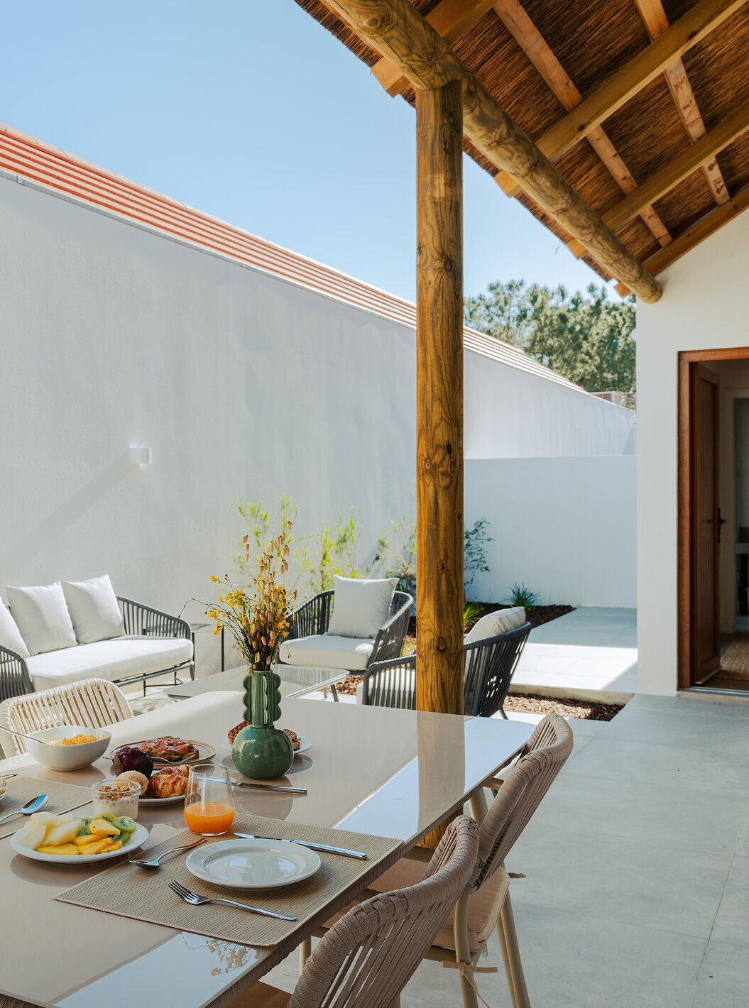 A Superior Villa do Pestana Comporta Village Residences tem um pátio exterior com uma mesa de refeição e um sofá