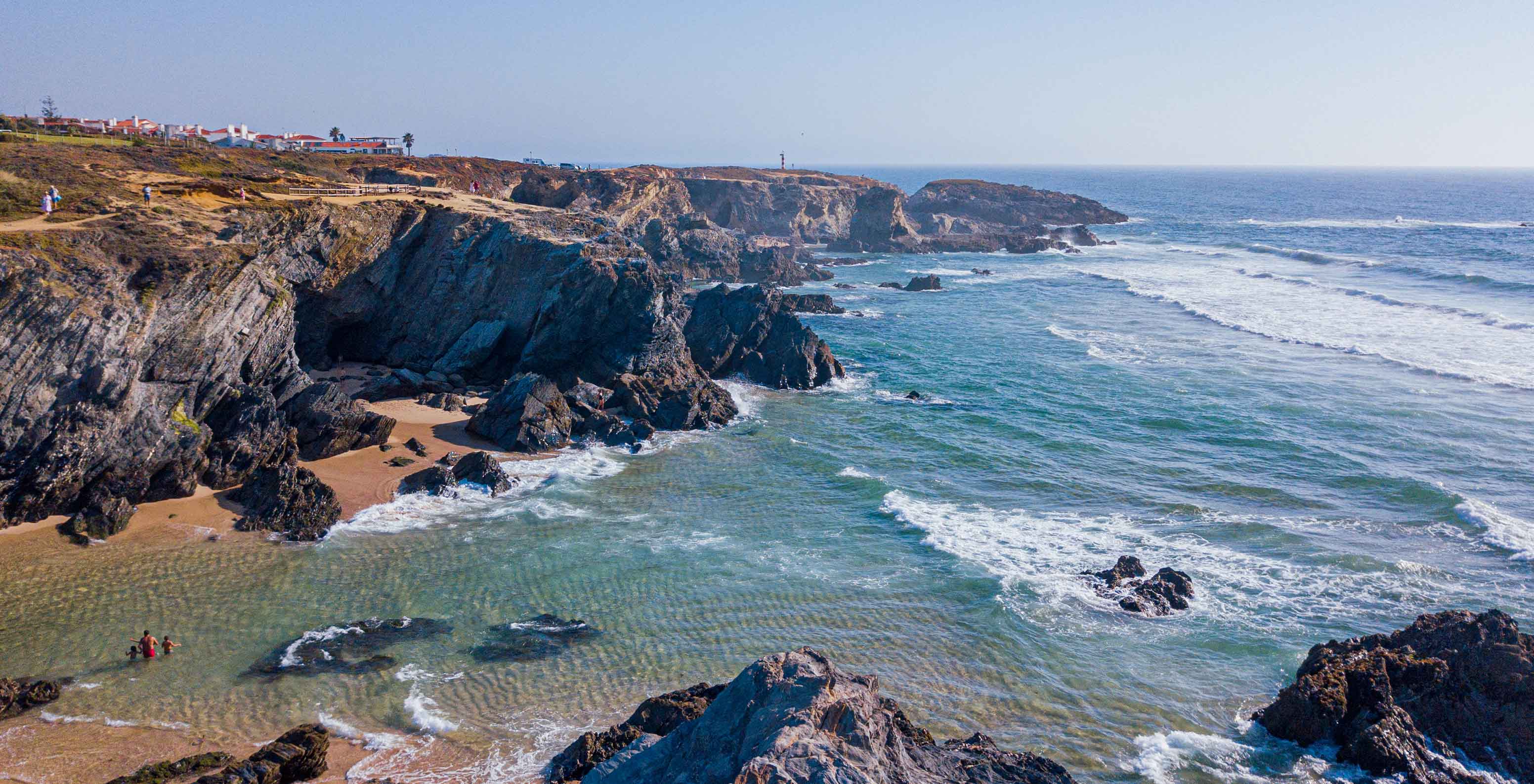 Falésias rochosas e mar azul junto à costa perto do Pestana Porto Covo Village