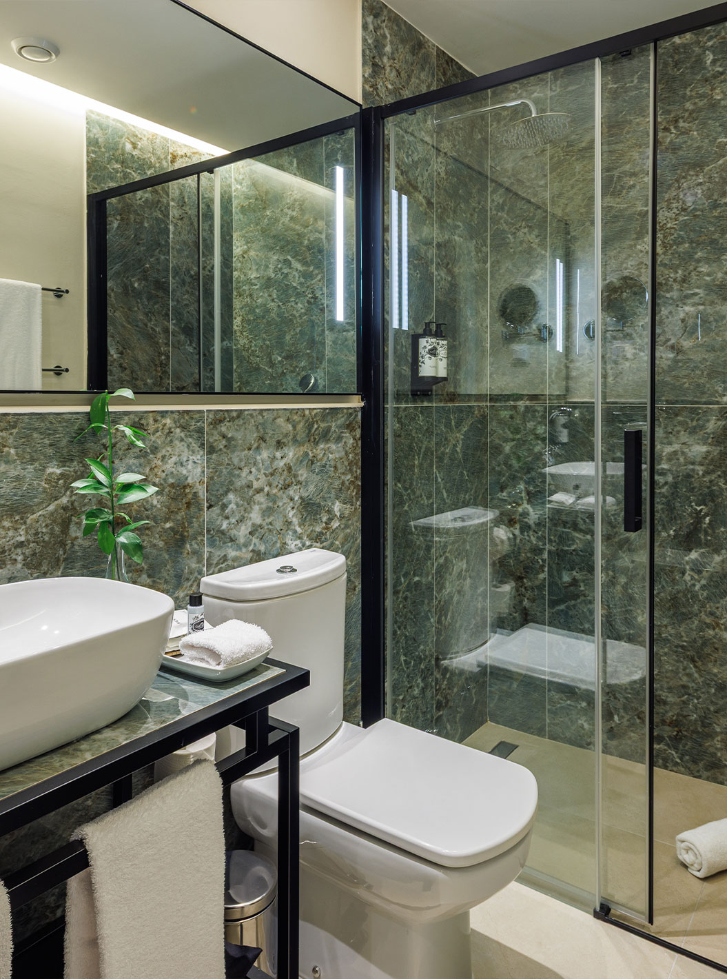 O Familiar Vista Jardim do Pestana Vila Sol - Vilamoura tem uma casa de banho em mármore verde com sanita, lavatório e duche