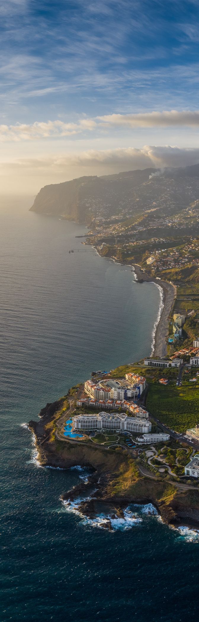 Vista aérea da cidade do Funchal, na Madeira, com áreas urbanas densas e montanhas ao fundo