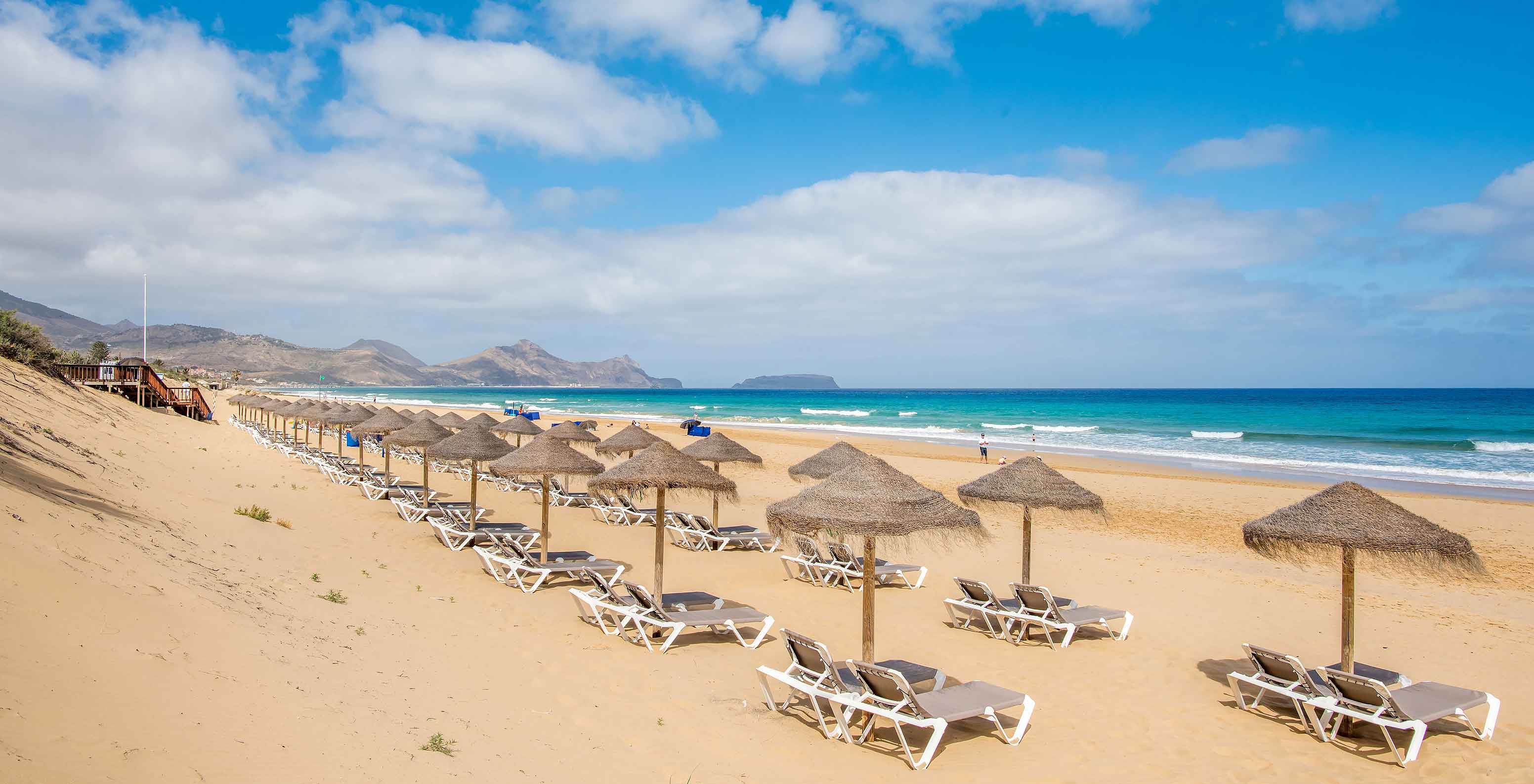 Bar de praia do Pestana Porto Santo, Resort de 5 Estrelas no Porto Santo, com espreguiçadeiras e chapéus de palha na areia